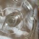 Standing molded glass cup depicting a flower