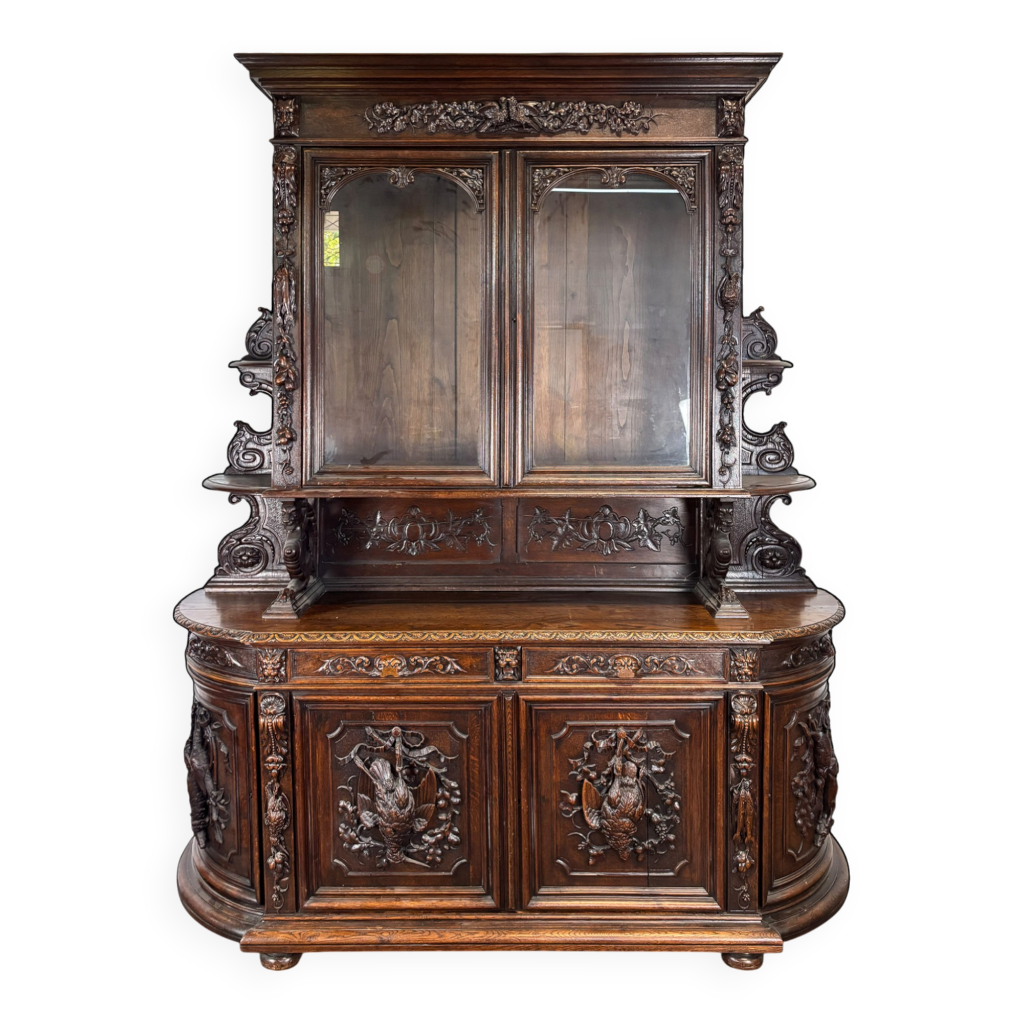 Buffet deux corps de chasse de style Henri II en chêne sculpté vitré