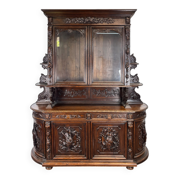 Buffet two-body hunting cabinet in carved oak with glass, in Henri II style.