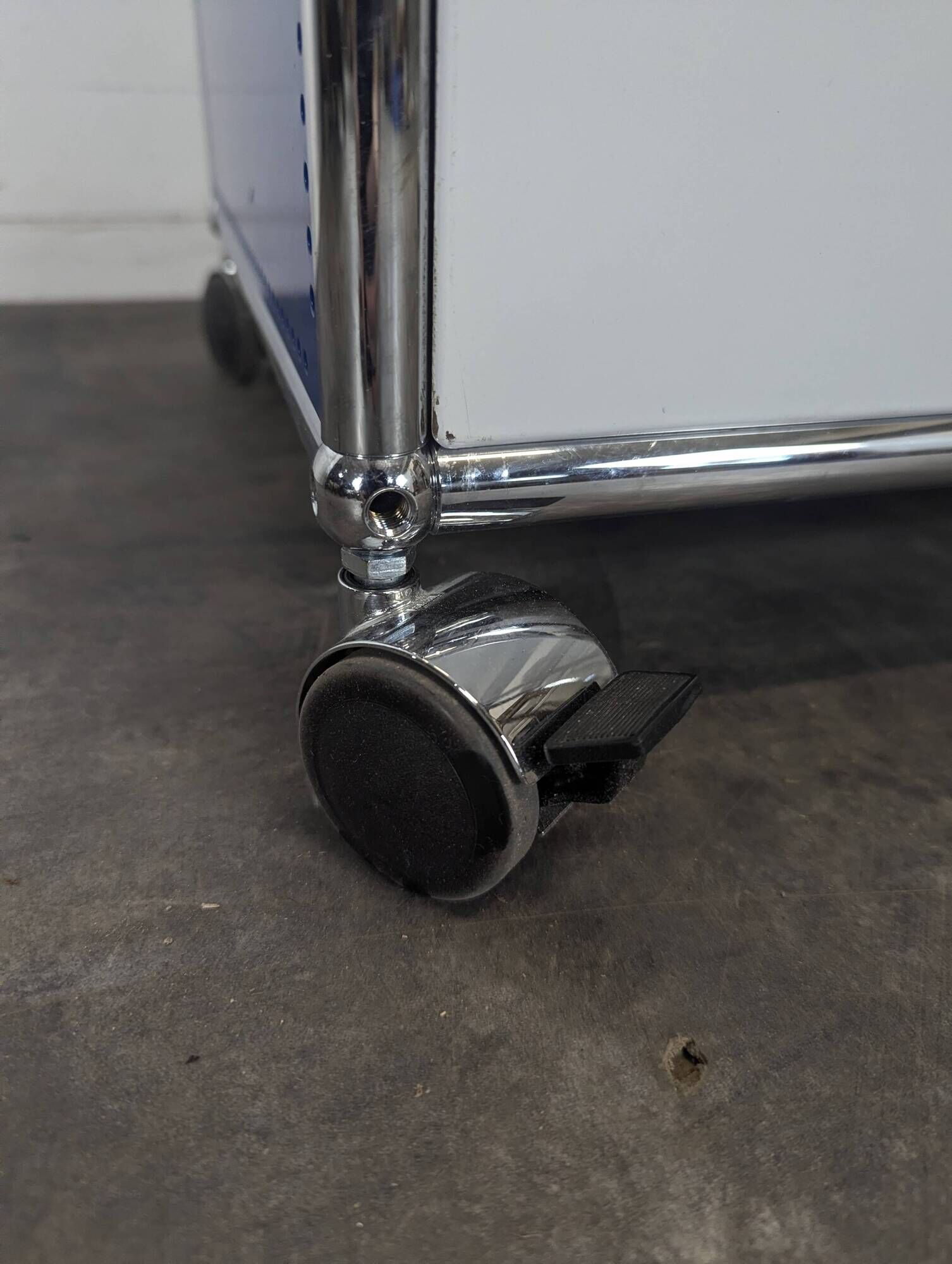 USM Haller furniture in gentian blue and white with a drop-down door on wheels.