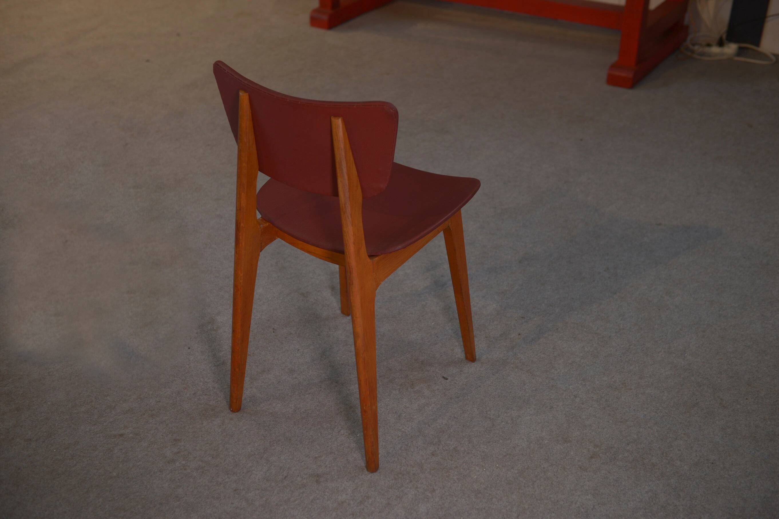Set of 4 designer chairs in oak and red leatherette from the 1960s