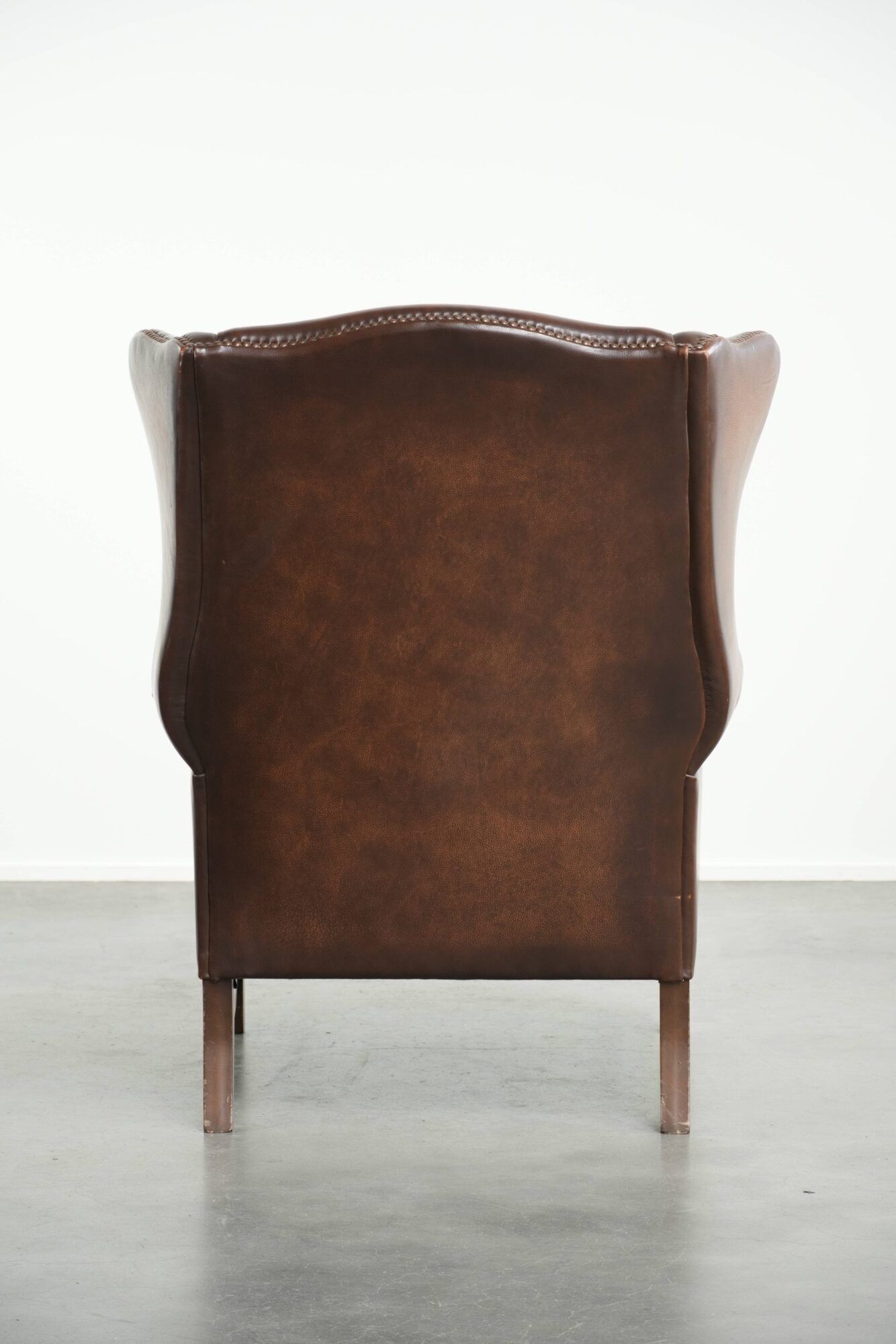 Cowhide wingback armchair in English style finished with decorative nails