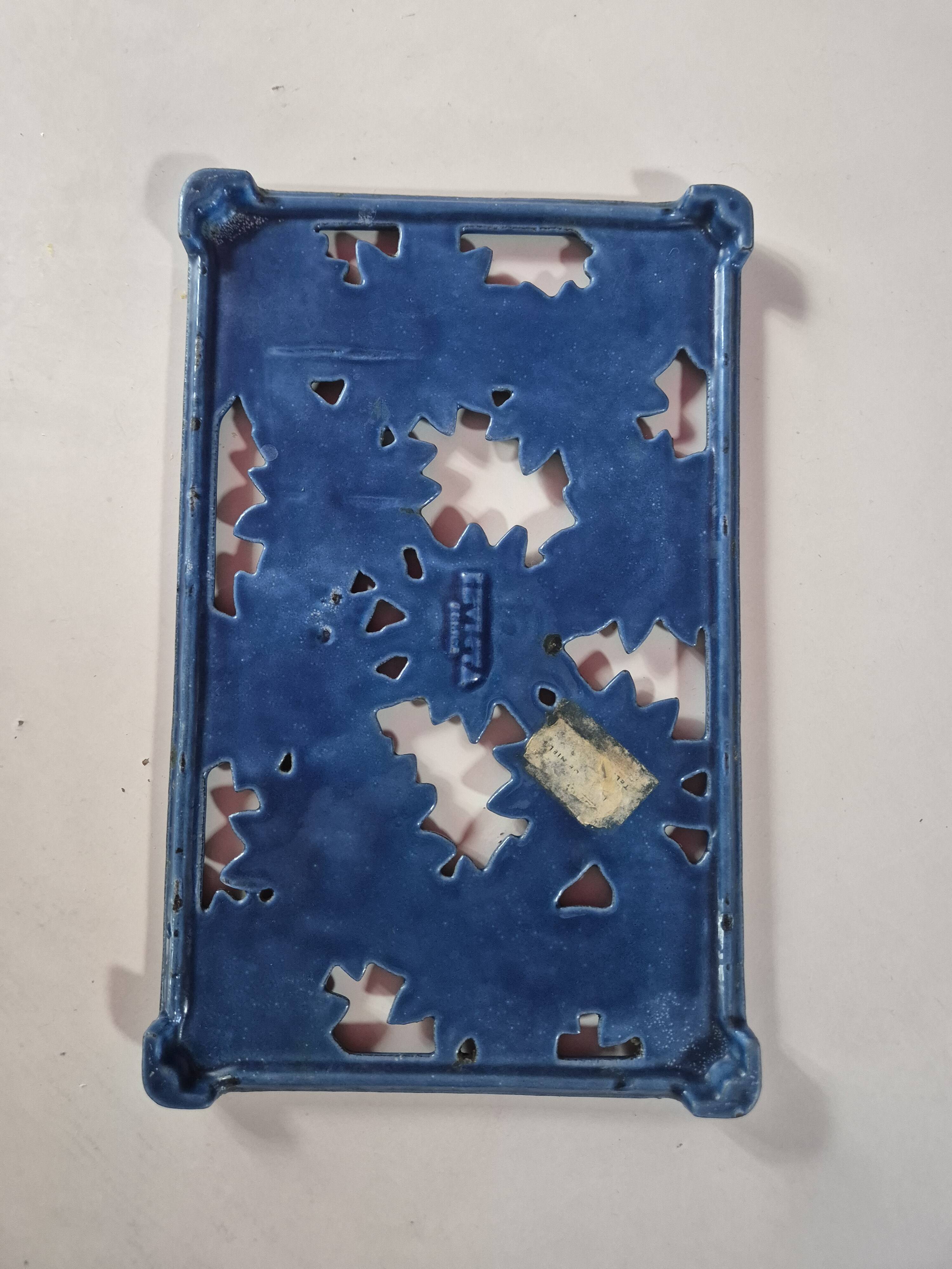 Blue cast iron trivet with flowers, small chip in the paint otherwise very good.