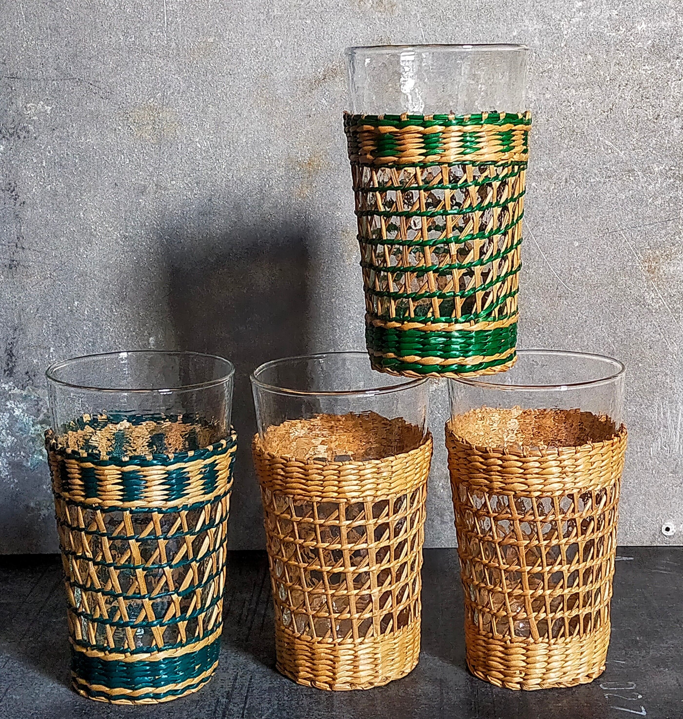 Four long drink glasses in vintage woven rattan cases