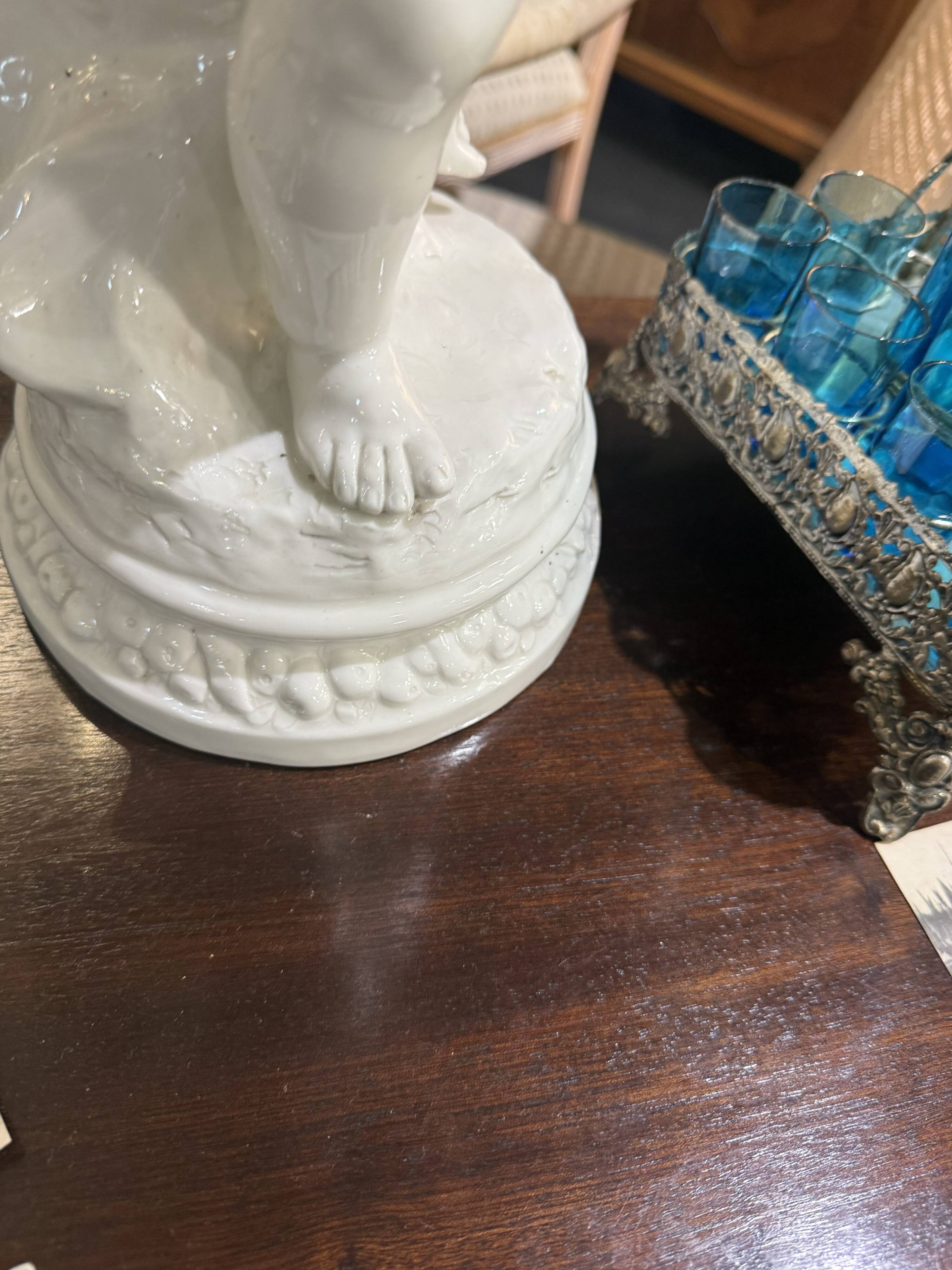 Child statue with flowers in porcelain, signed.
