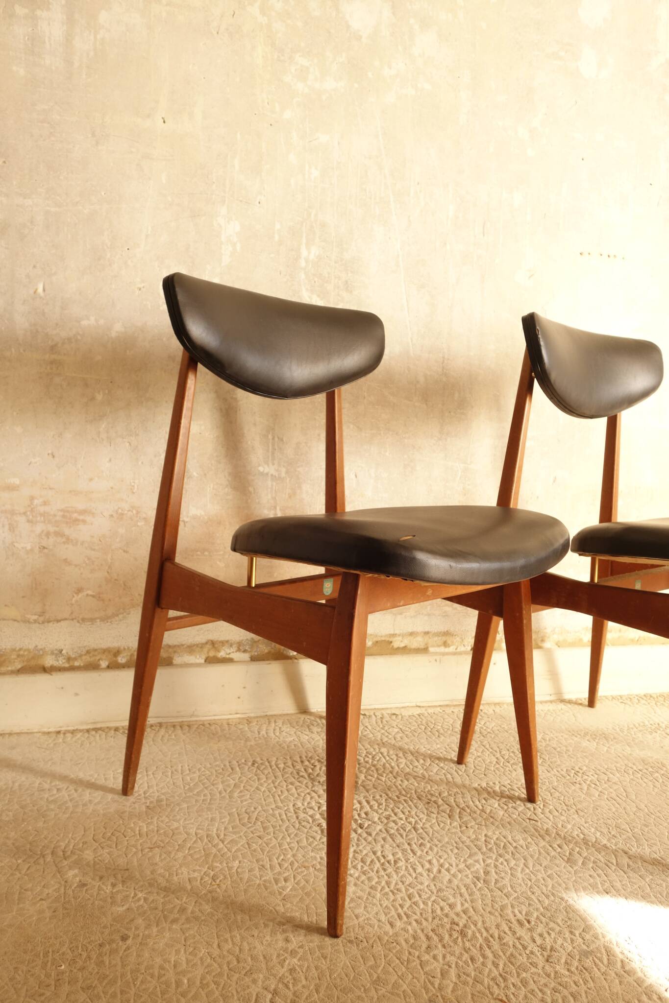 Pair of modernist Scandinavian chairs in teak and black faux leather.