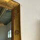 Miroir doré style Restauration à décor de palmettes étirées