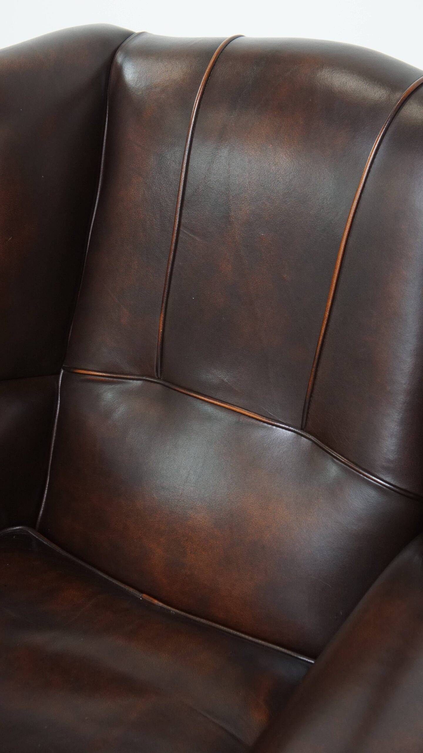 Comfortable wingback chair in English style made of cowhide leather