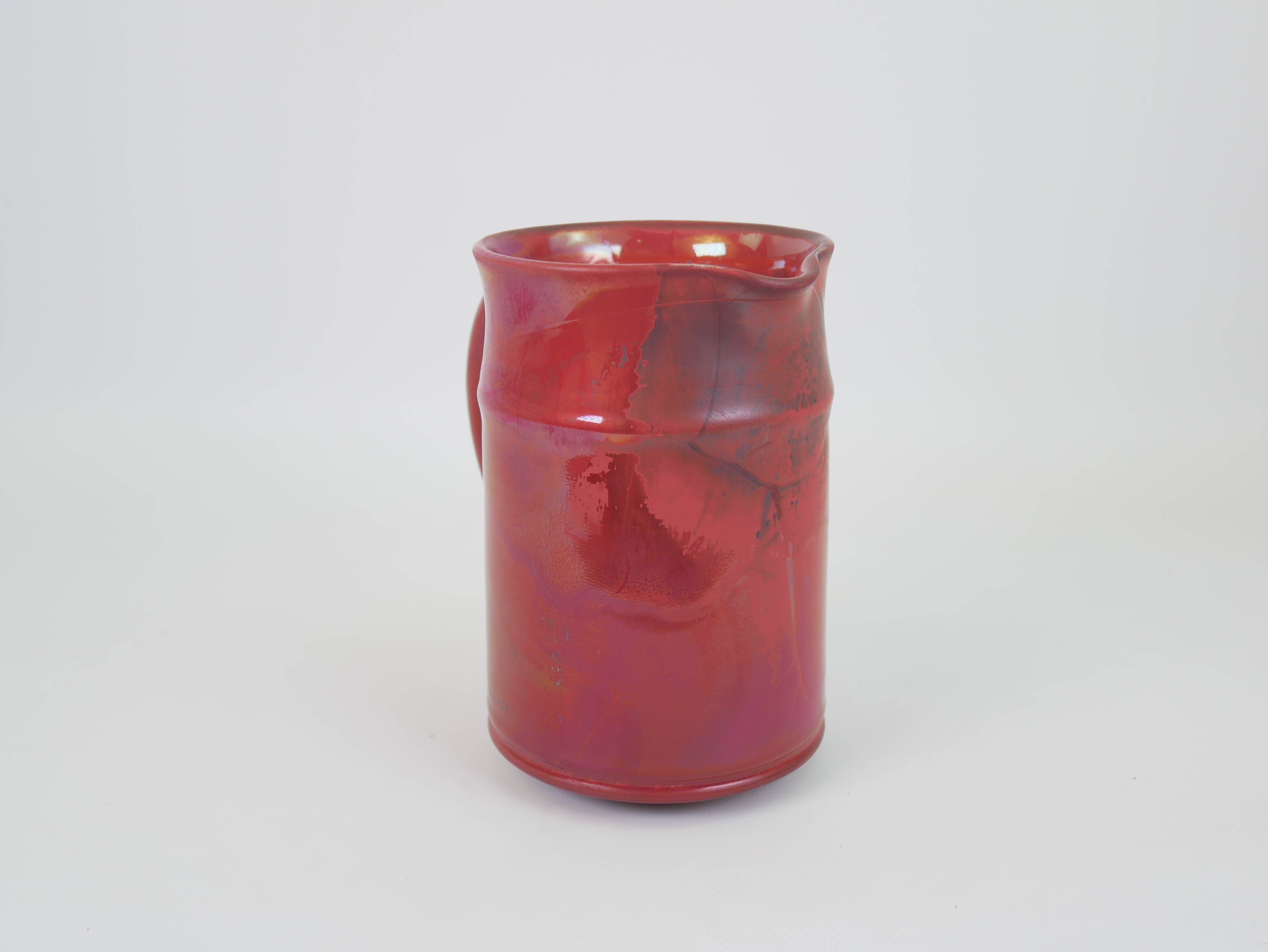 Red glazed ceramic jug with relief