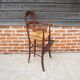 Old wooden high chair for children with straw.