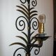 Wrought iron sconces decorated with golden pineapple leaves