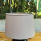 Vintage 80s table lamp with a black ceramic base and beige shade.