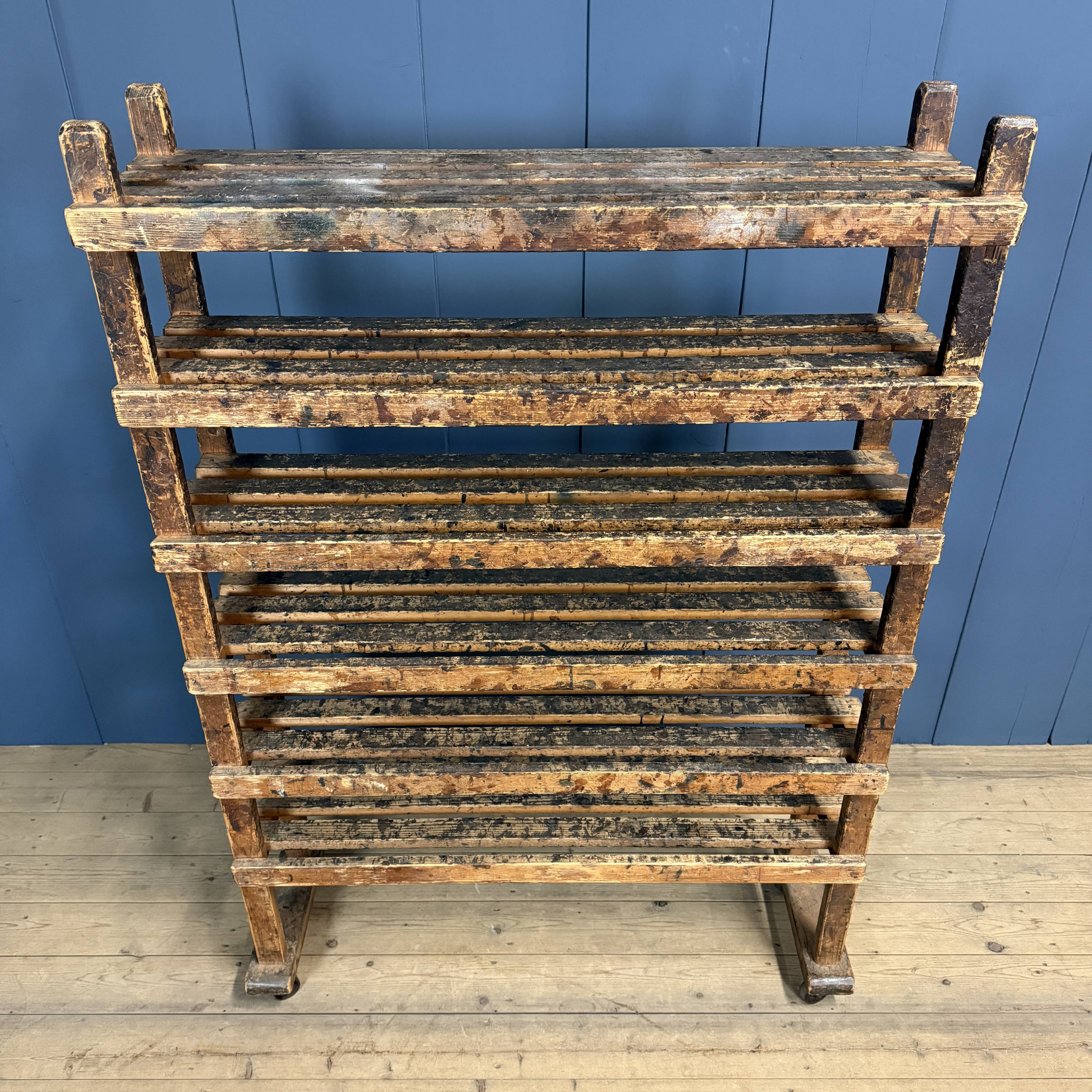 Old wooden workshop shelf with cast iron wheels.