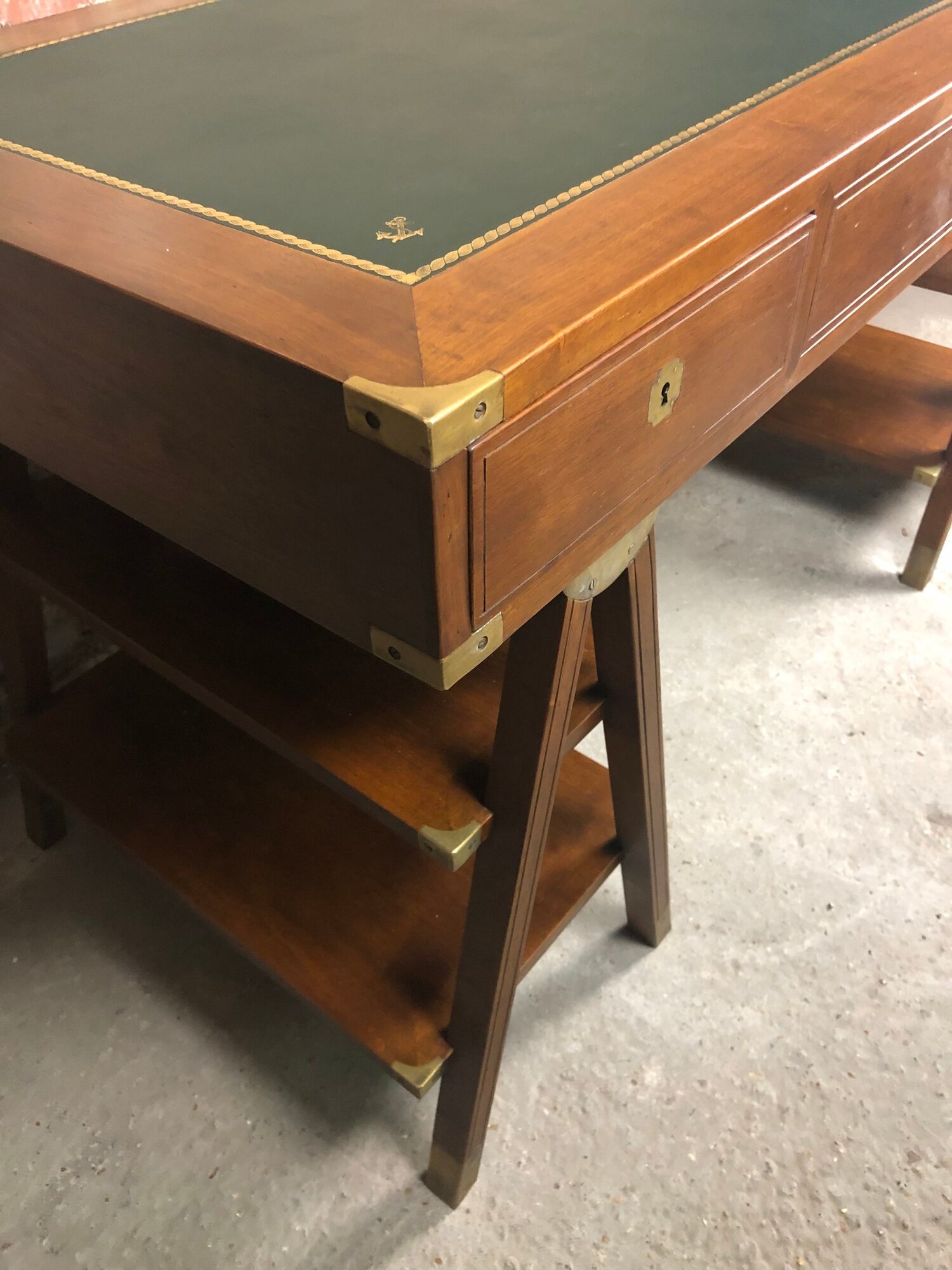 Walnut desk with green leather top resting on two trestles