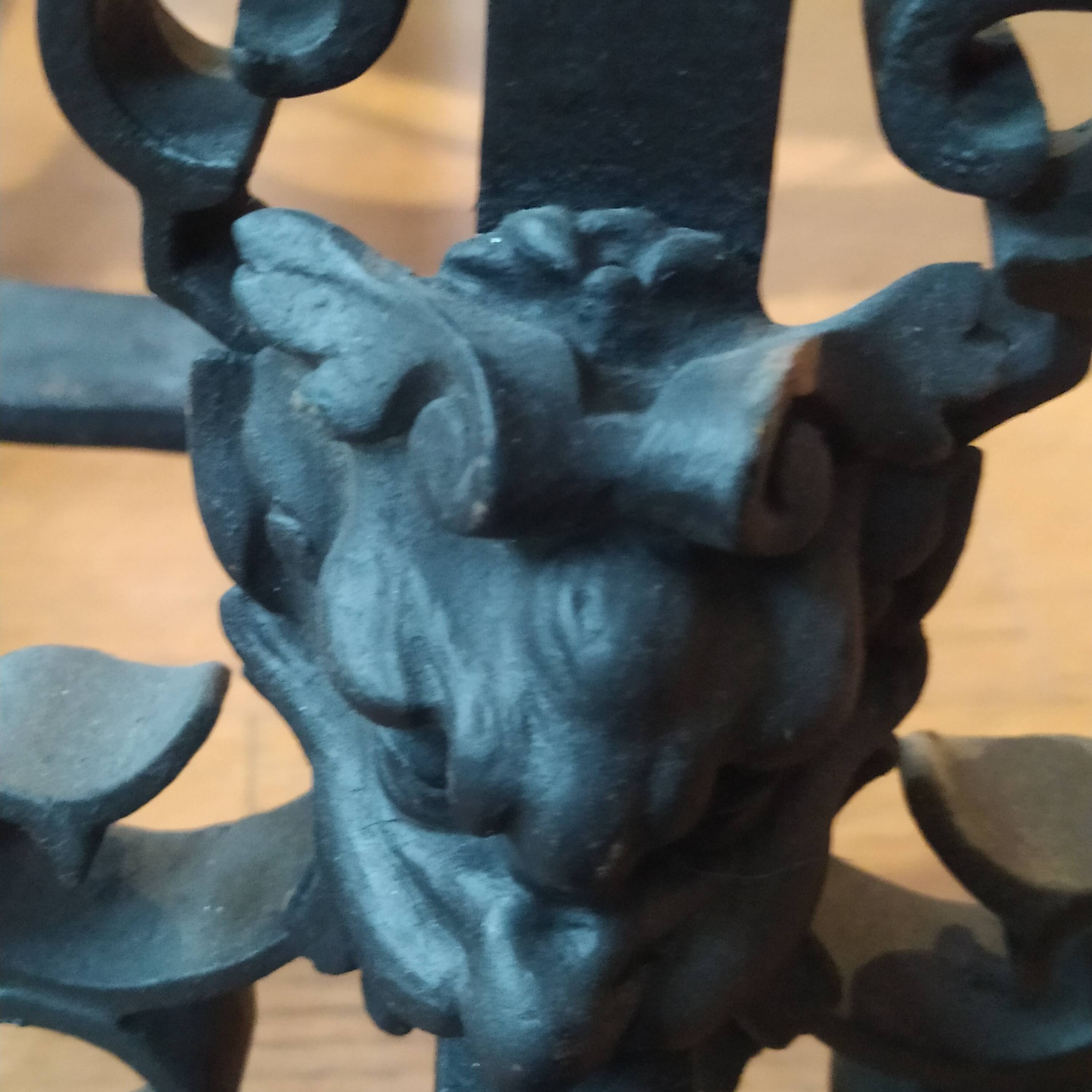 pair of large 20th century metal andirons with mascaron decoration