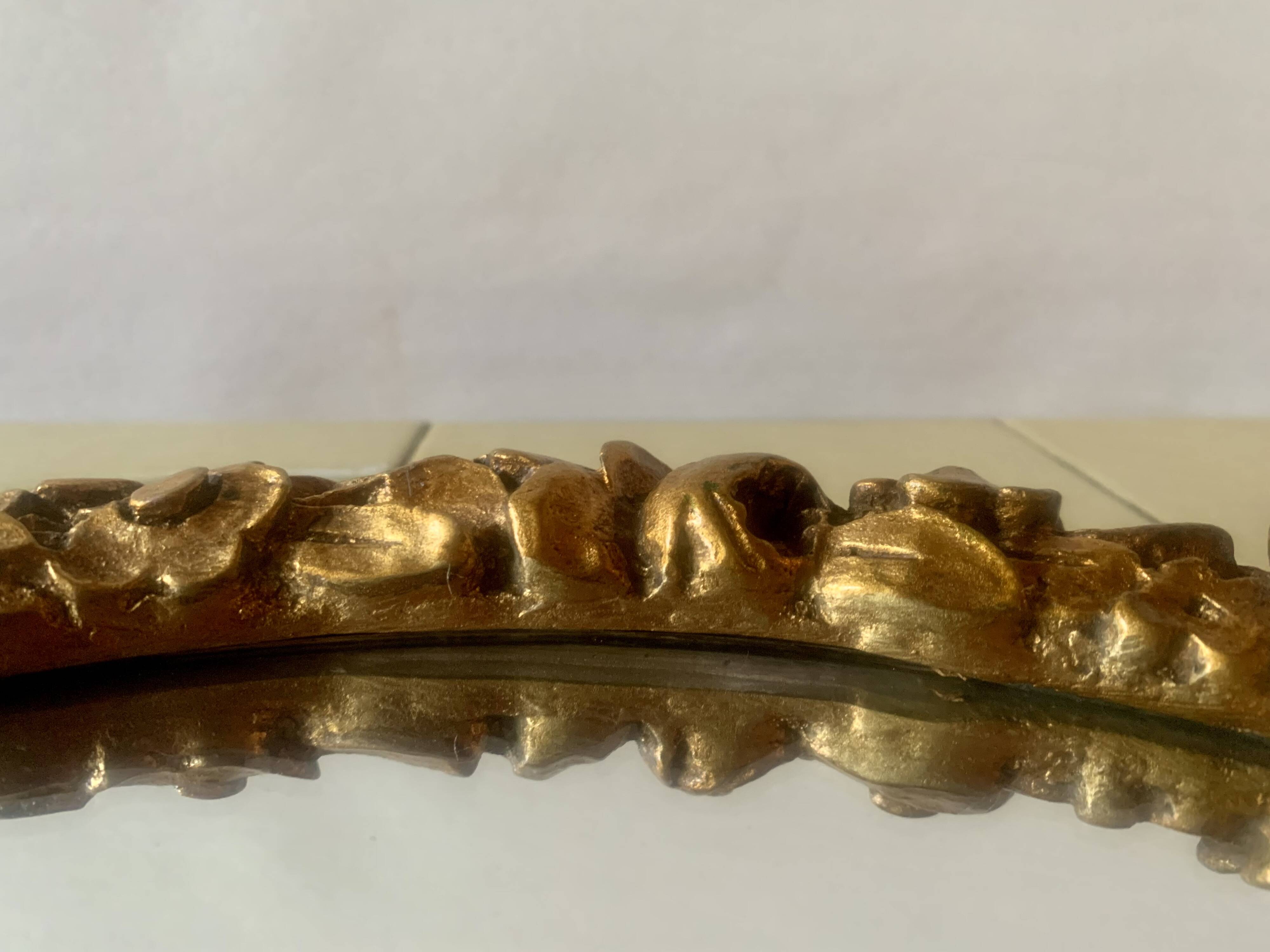 Small vintage oval wall mirror in varnished gold resin