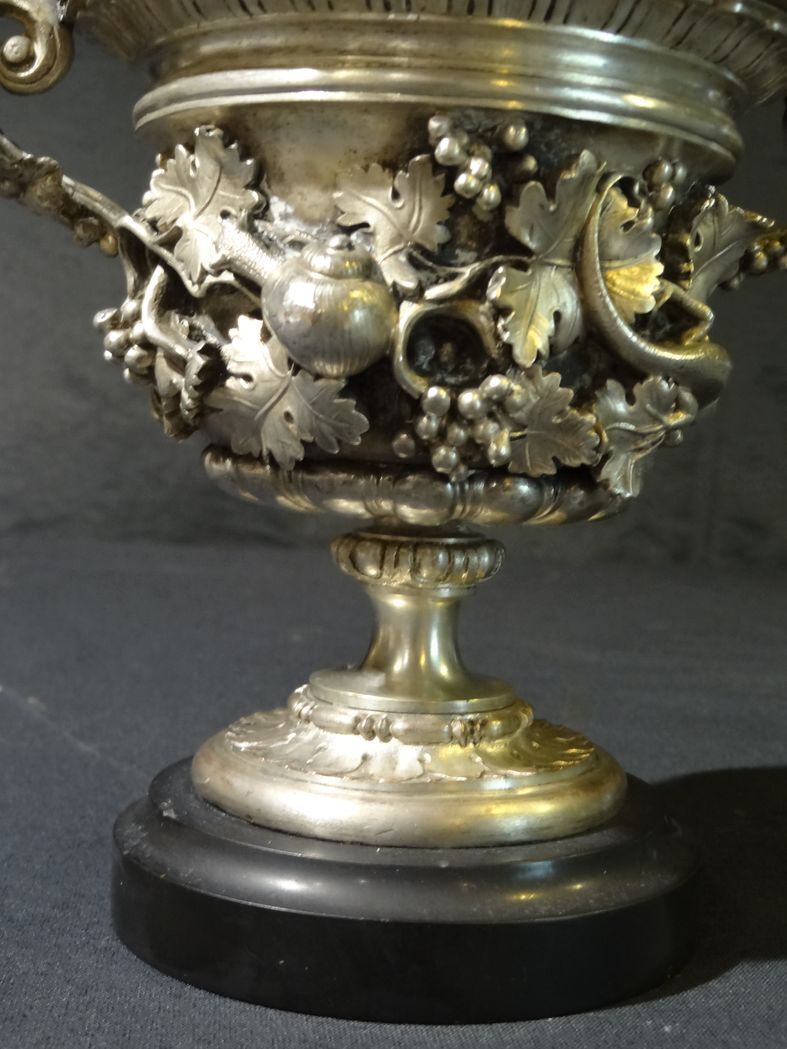 Carved silver bronze vase mounted on marble pedestal