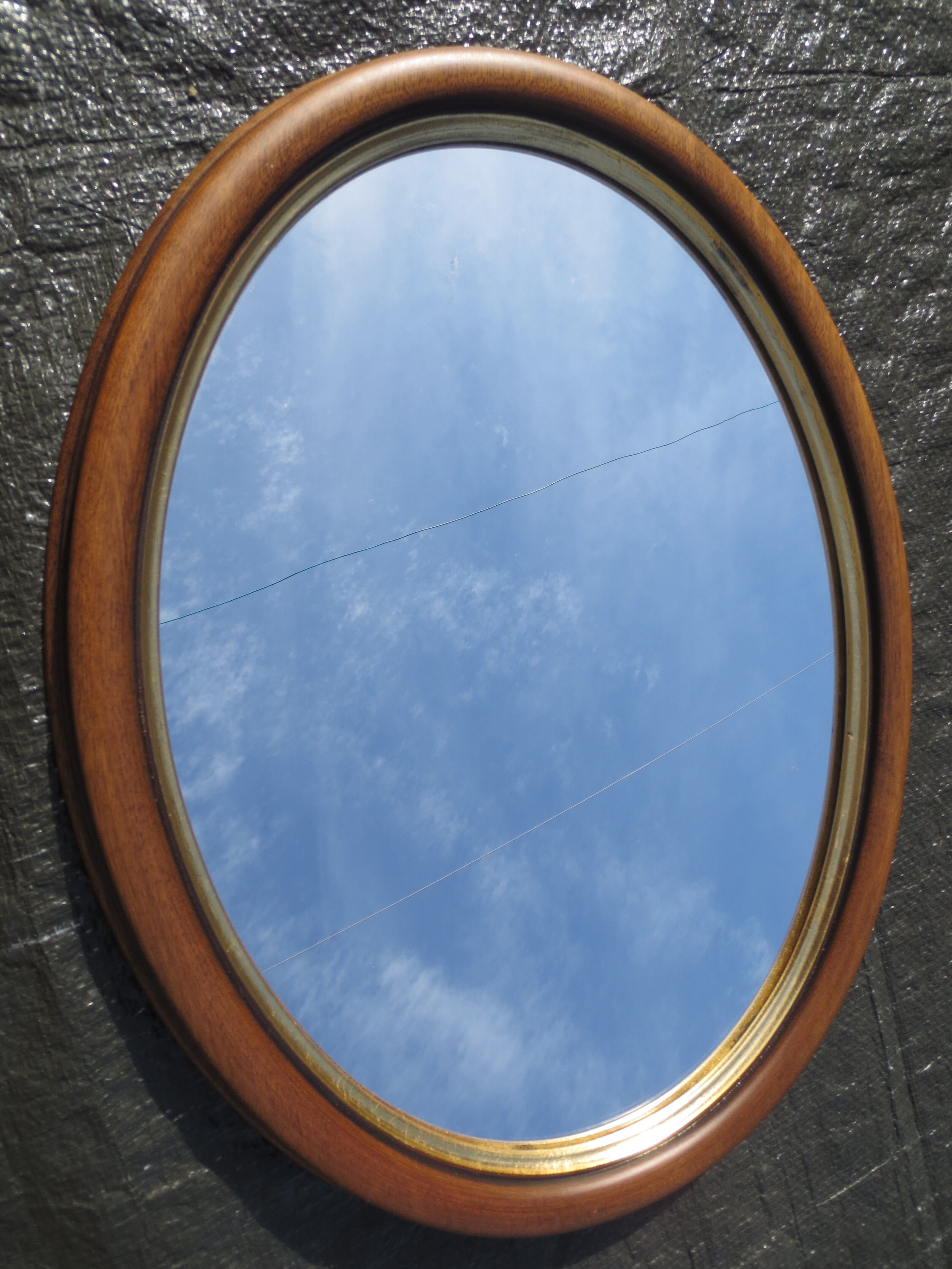 Old oval mirror, walnut wood tower, gilded border