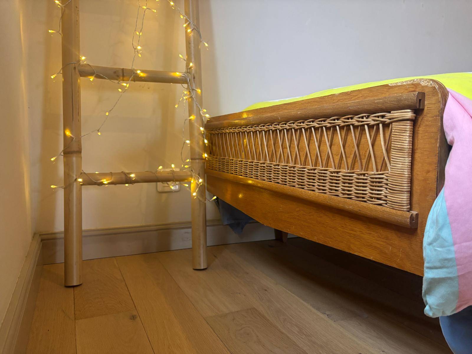 Vintage single bed made of rattan from the 1970s with a mattress.