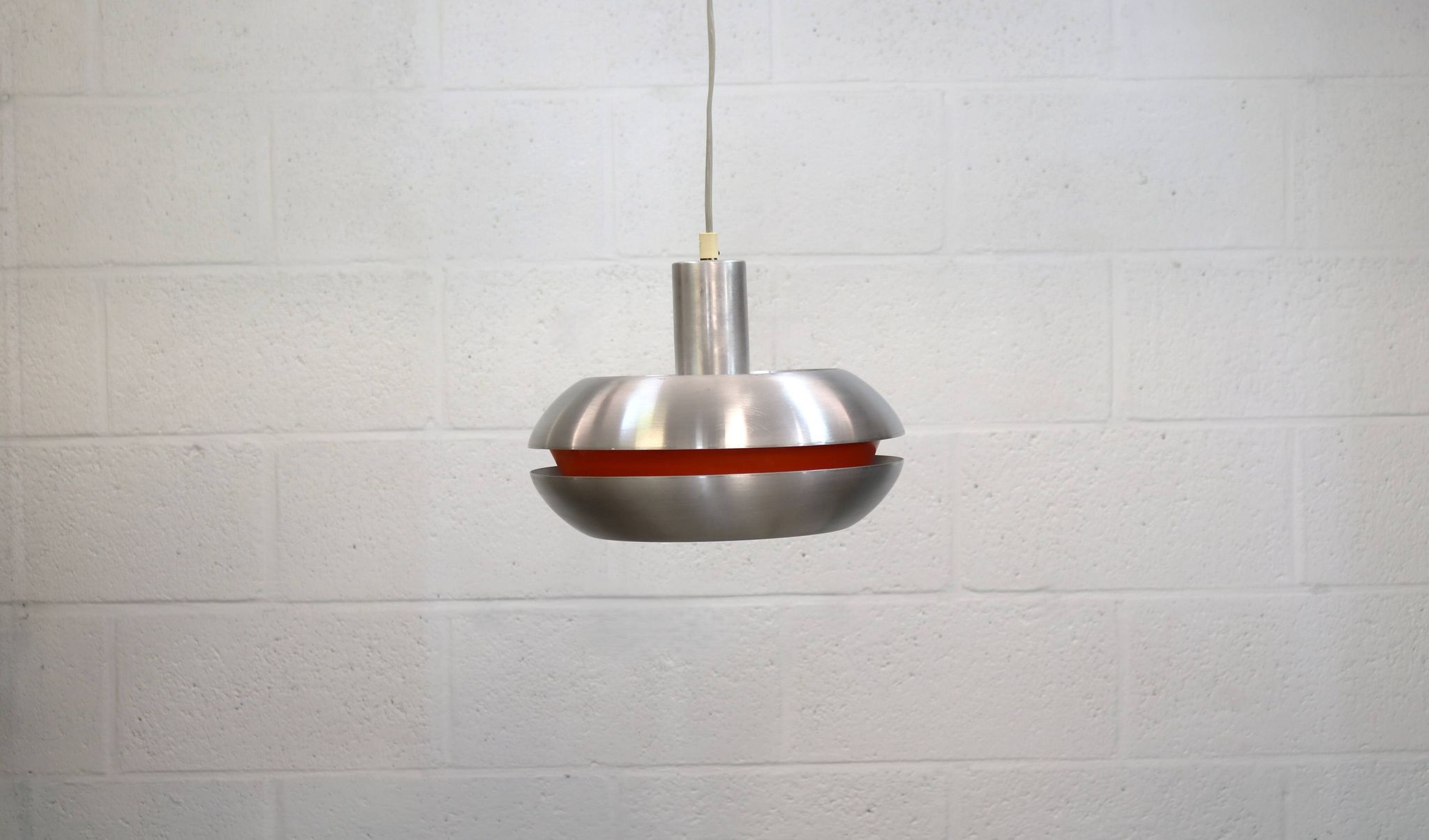 Ancienne lampe de design danois de l'ère spatiale en aluminium avec intérieur orange.