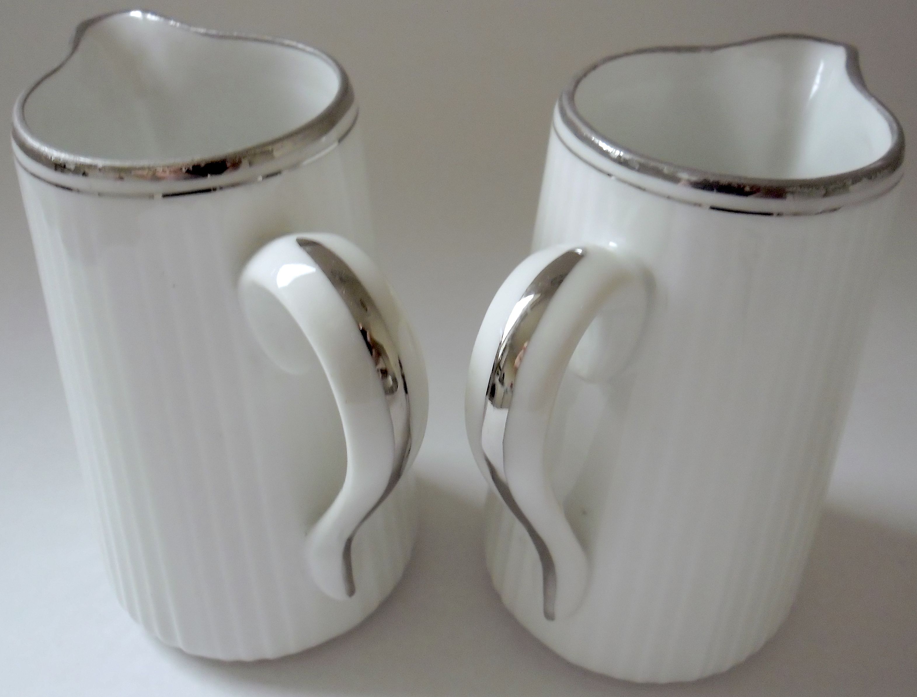 Pair of creamers in white porcelain enhanced with platinum