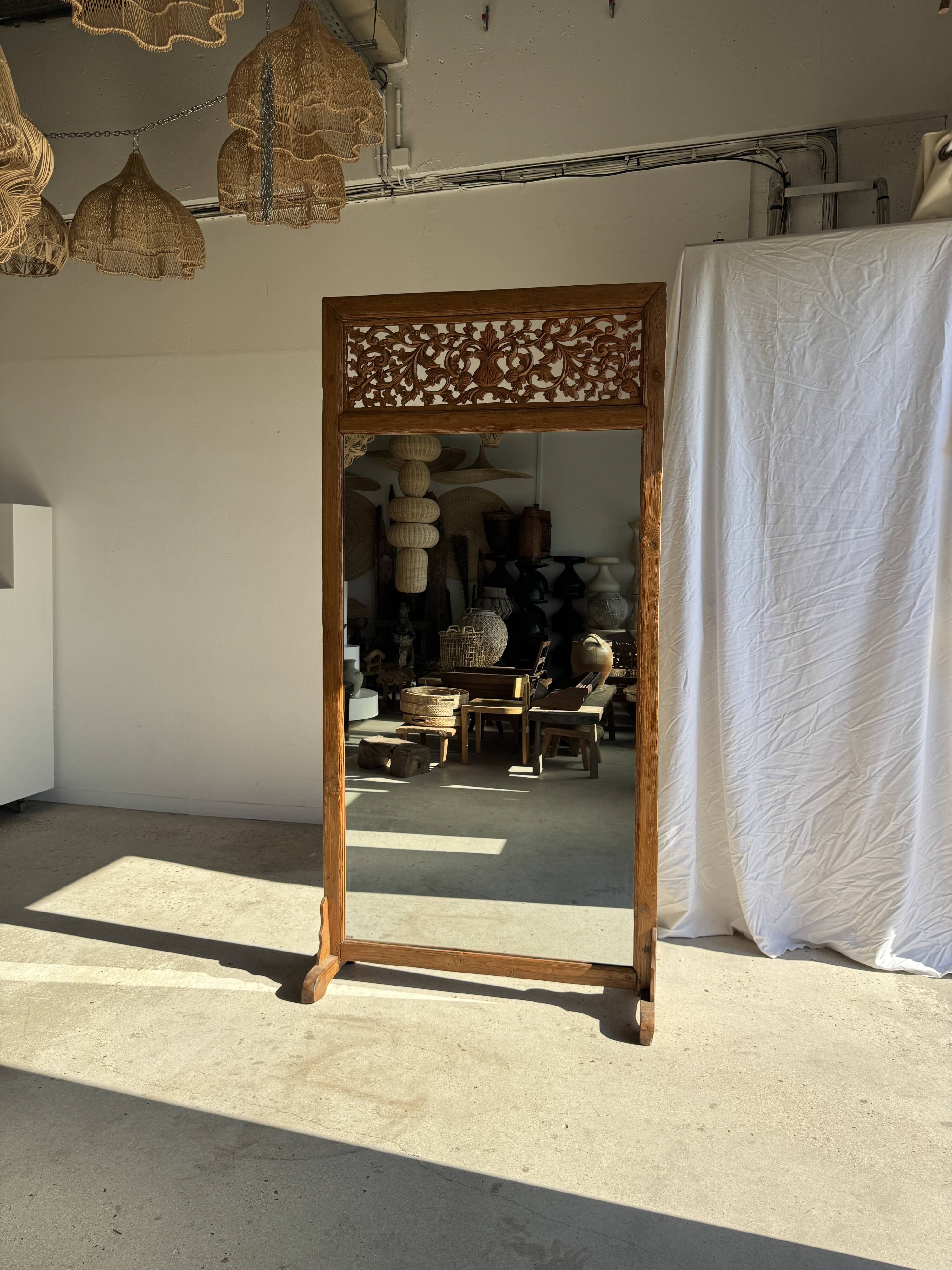Very large freestanding teak mirror with an openwork carved pediment, Indonesia.