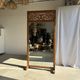 Very large freestanding teak mirror with an openwork carved pediment, Indonesia.