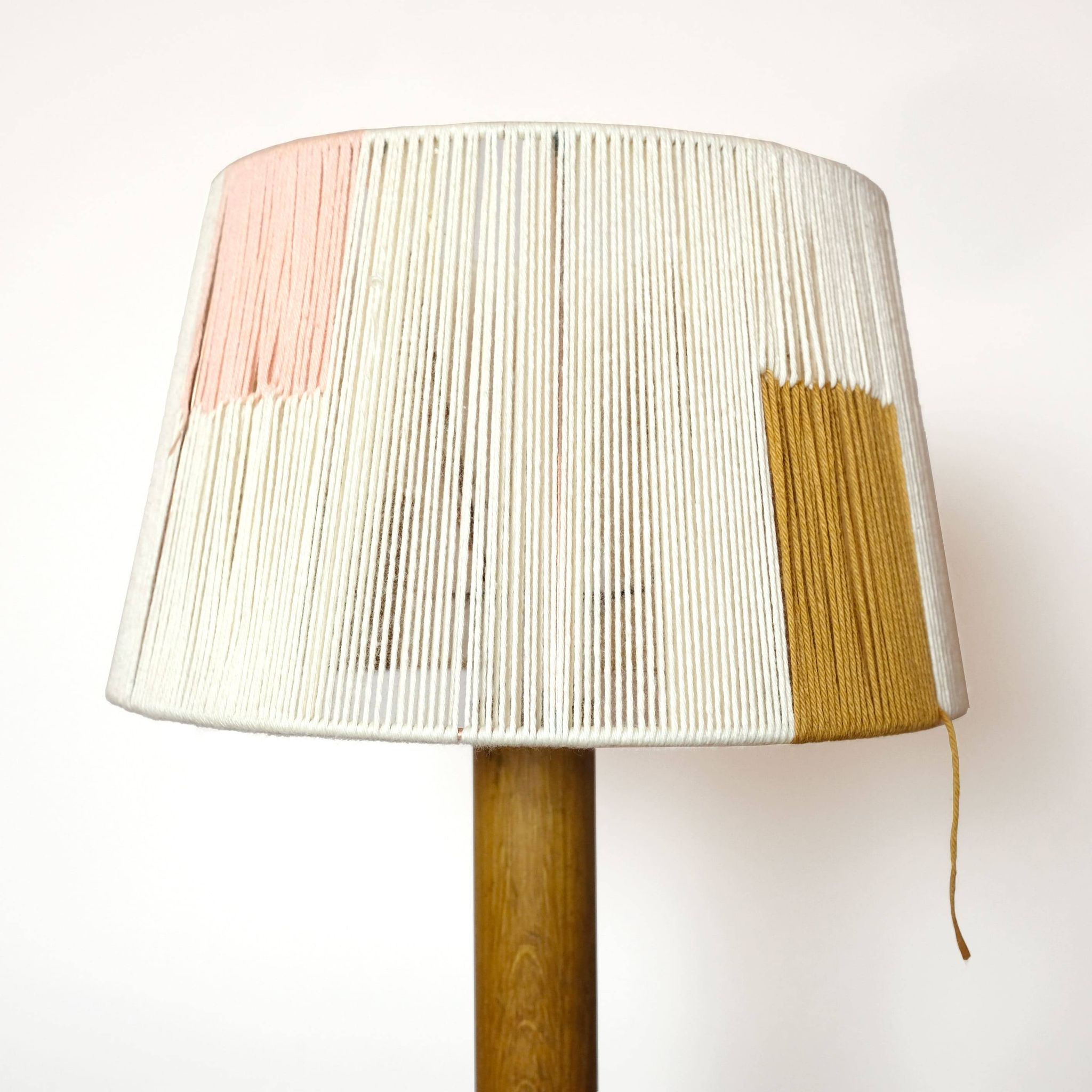 Wooden candle holder mounted as a lamp and its rope shade, 47.5cm.