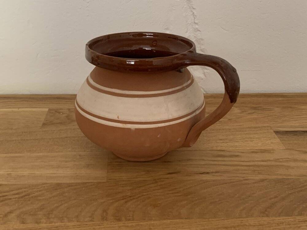 Hungarian folk ceramic pitcher in glossy brown and beige, traditional rounded pot.
