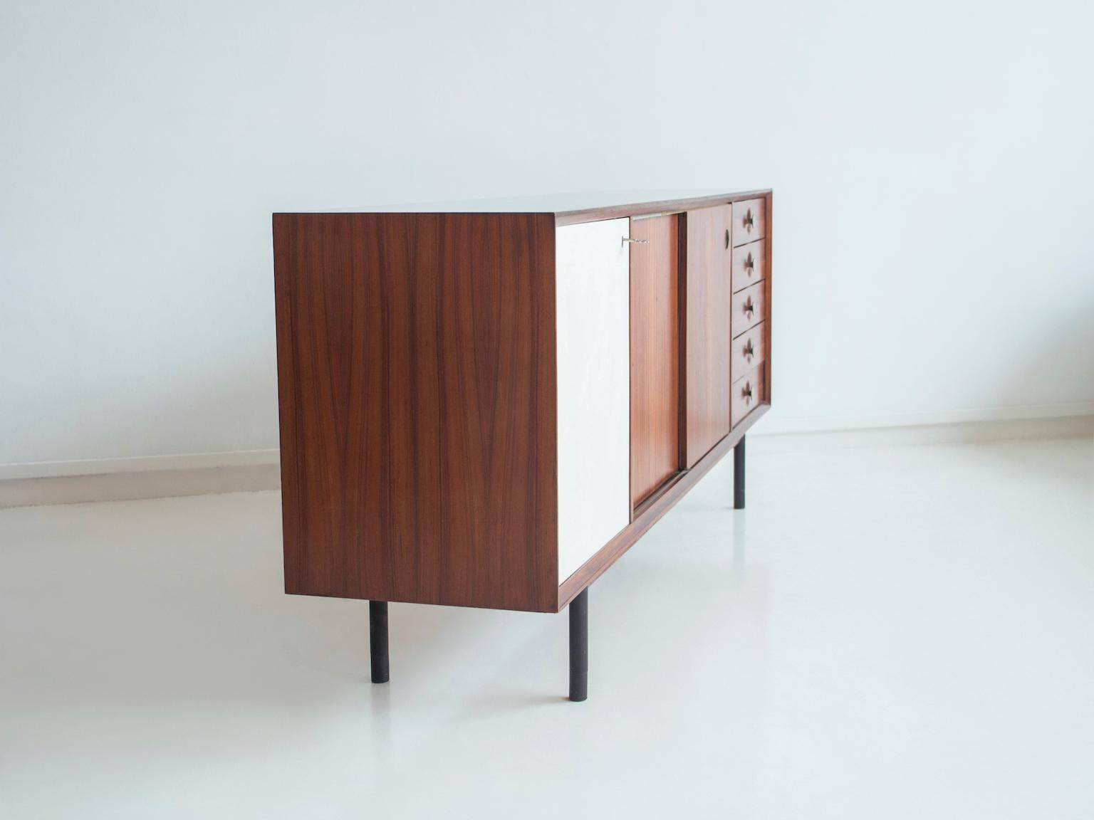 Wooden sideboard with sliding door and white drawers, around 1960.