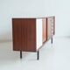 Wooden sideboard with sliding door and white drawers, around 1960.