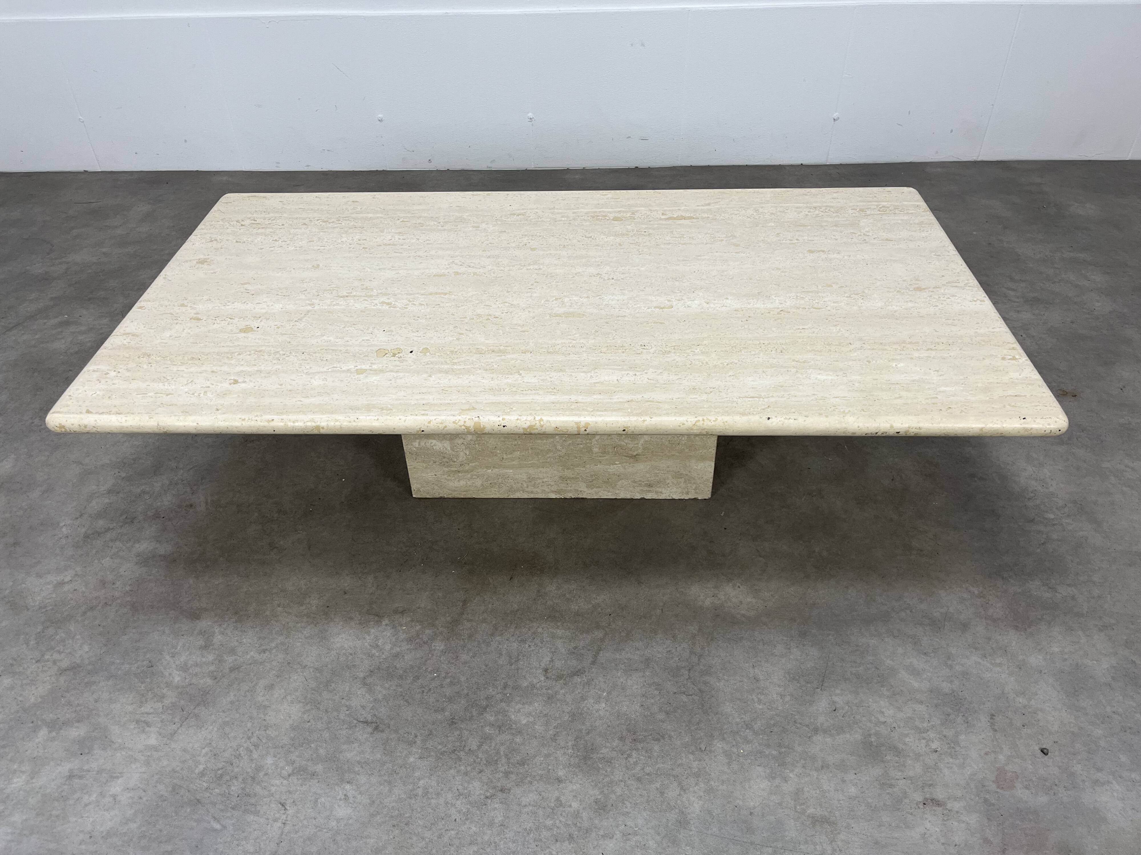 Rectangular travertine coffee table with central leg