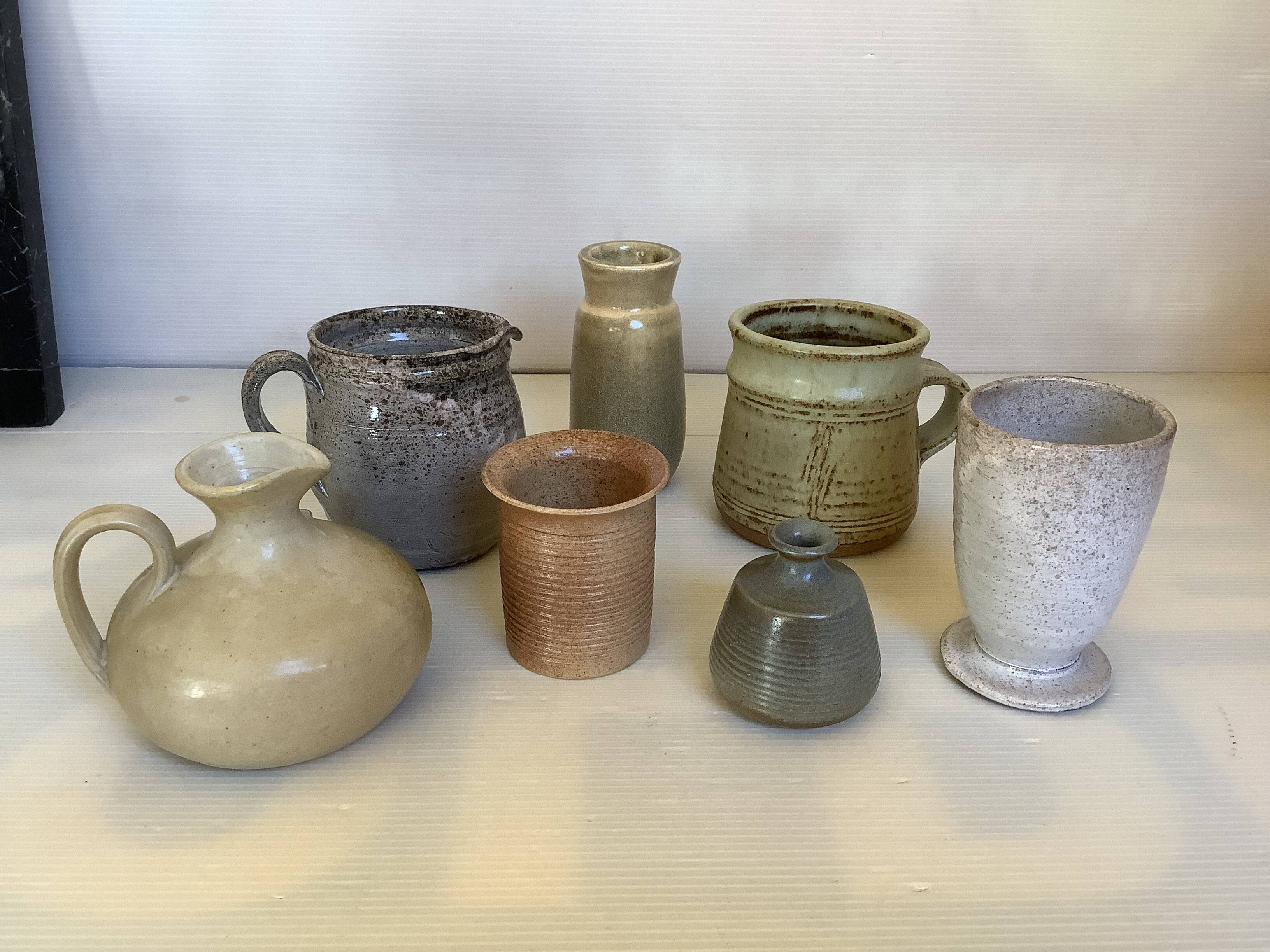 Seven beige and gray ceramic vases