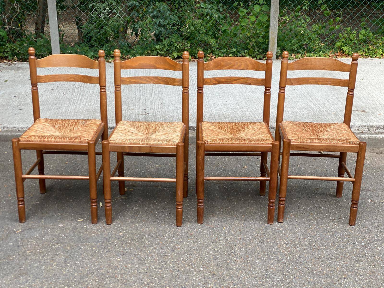 4 solid wood kitchen chairs with straw seats in a country farmhouse style.