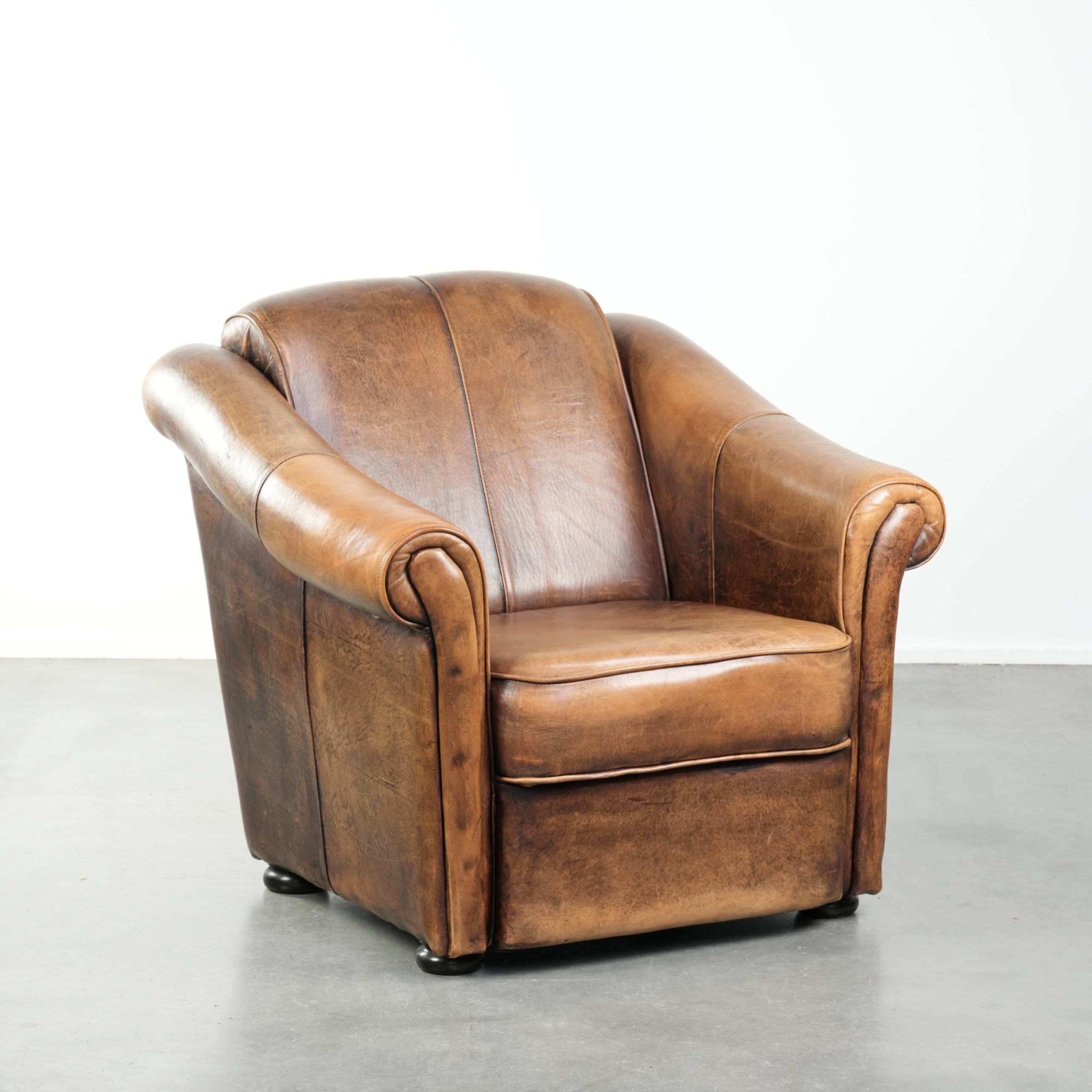 Fauteuil en peau de mouton magnifiquement conçu et confortable, avec un look intemporel et une finition de passepoil assortie.