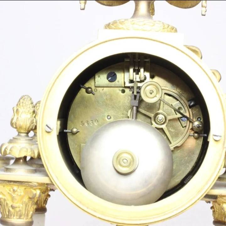 Clock and pair of Louis XVI style candelabras.