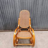 Curved wooden rocking chair with wicker cane rattan.
