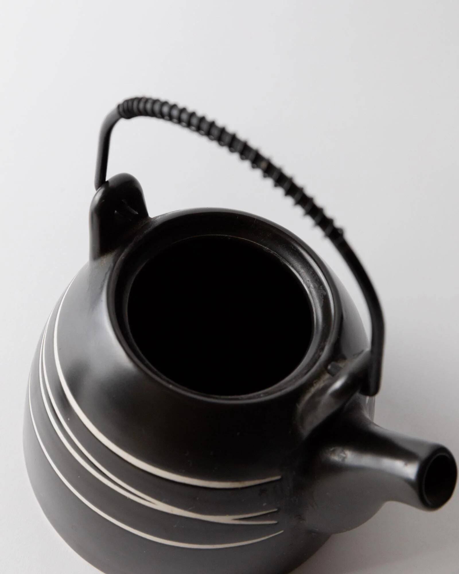 Vintage ceramic teapot from the 1980s, black with white stripes and a metal handle.