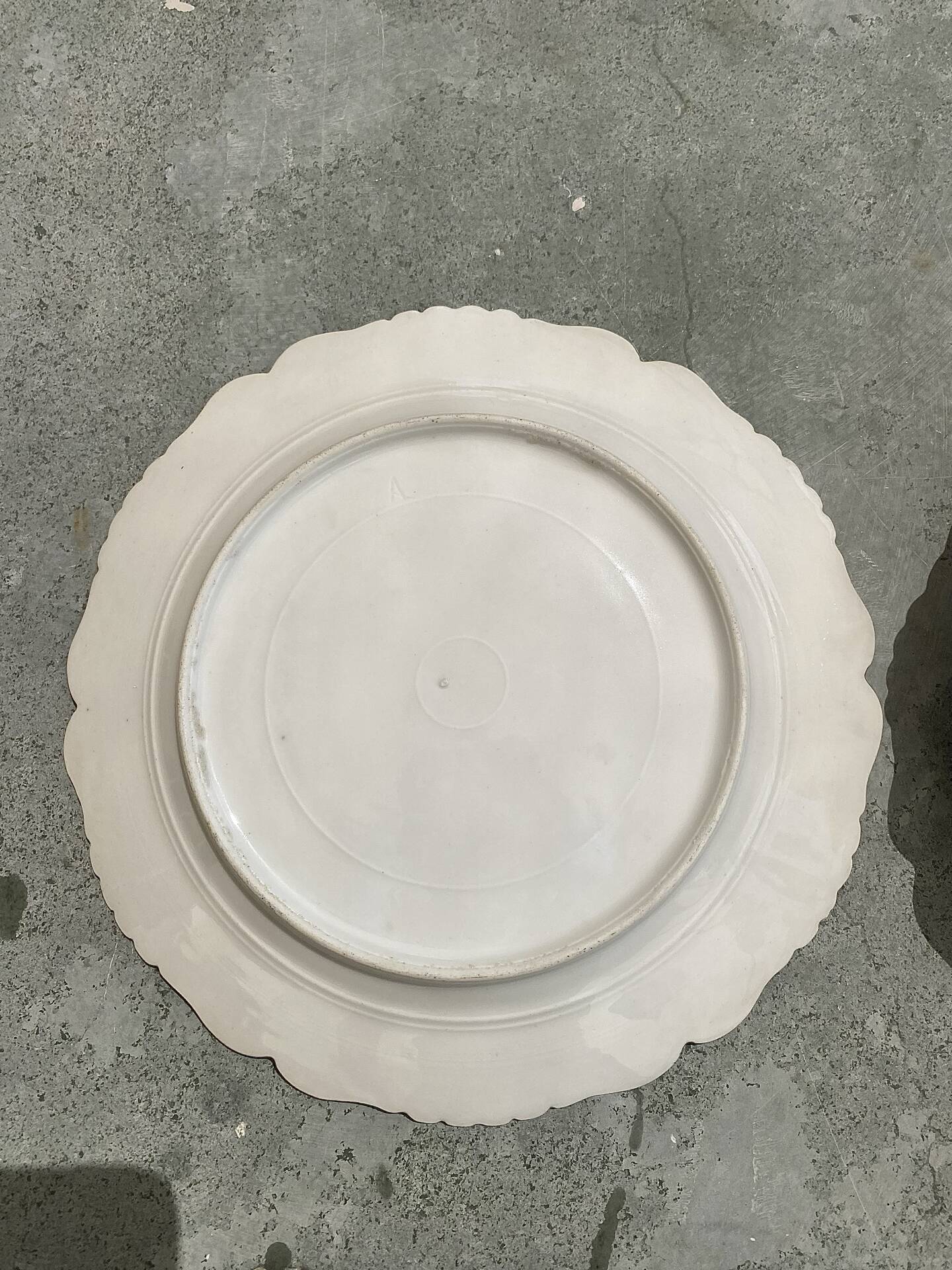 Antique plates from the late 19th century with scalloped edges and fruit decoration.
