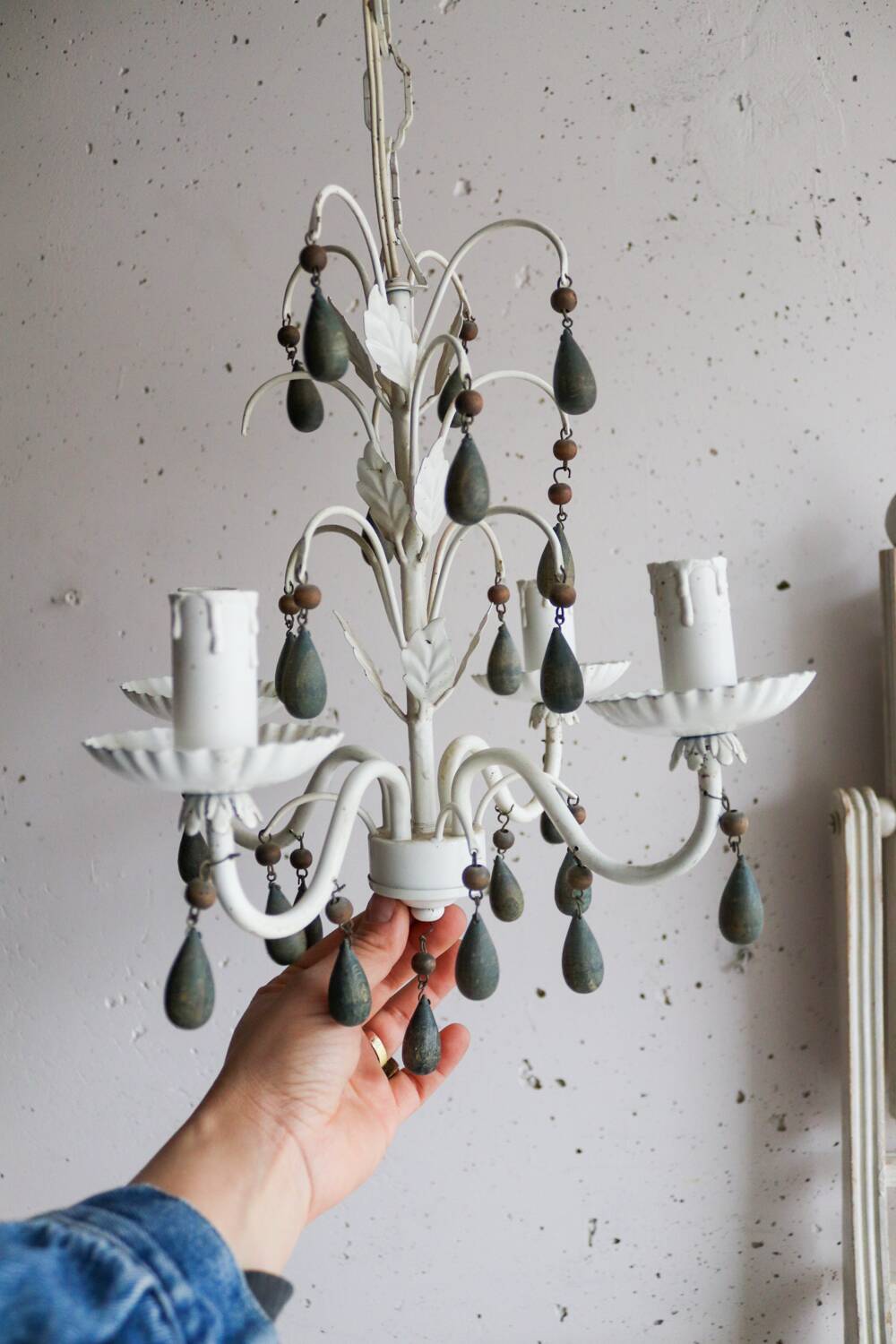 Antique white lacquered metal chandelier with wooden pendants.