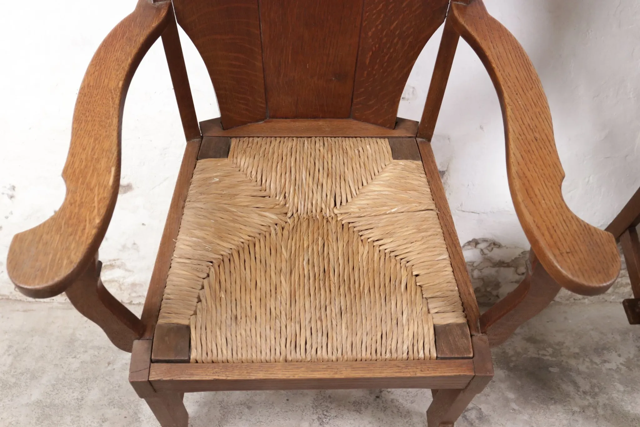 Pair of brutalist oak lounge chairs with rush seats – Netherlands