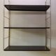Golden and brown stringed shelf in metal