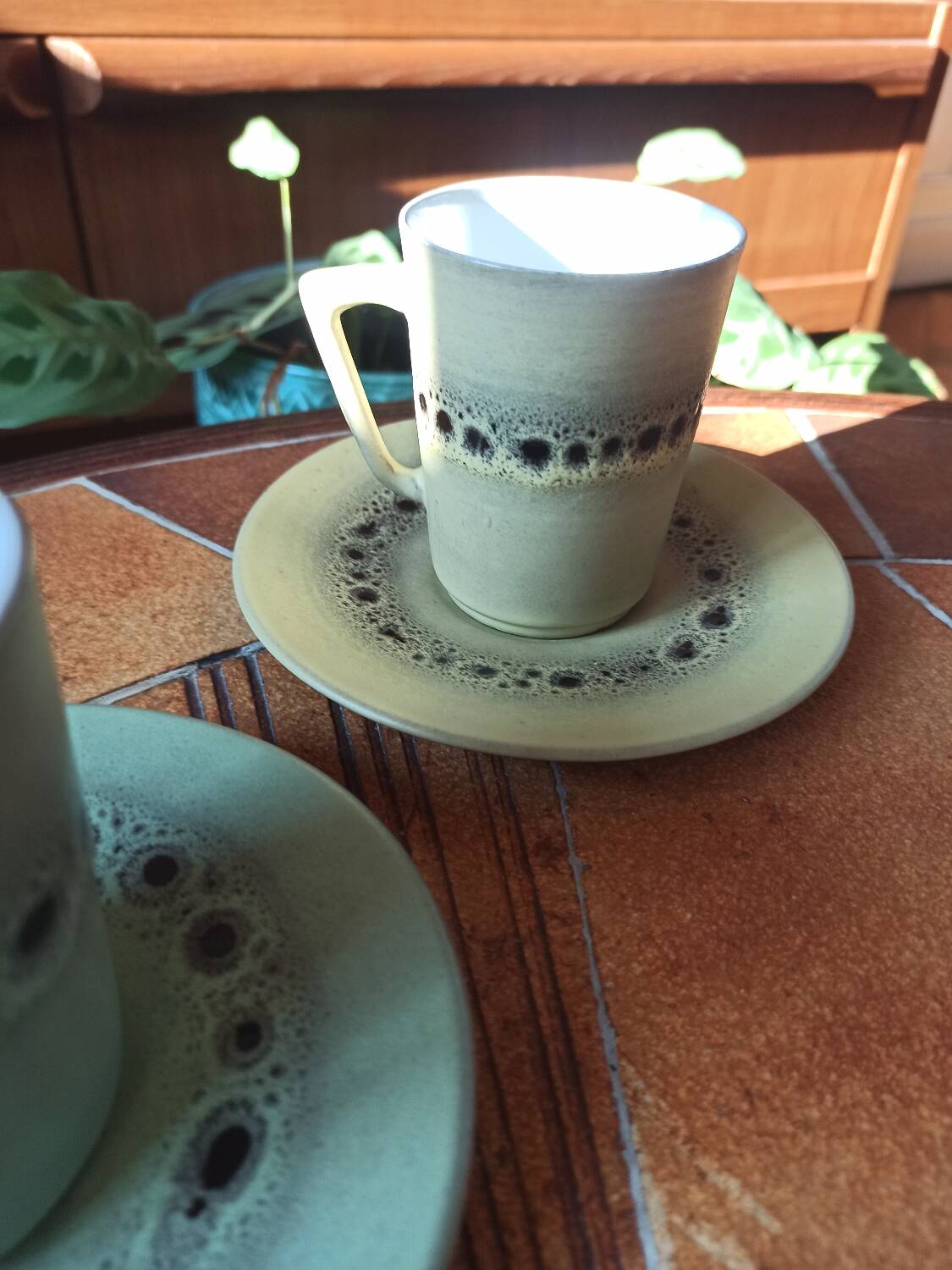 A pair of vintage glazed stoneware cups and saucers.