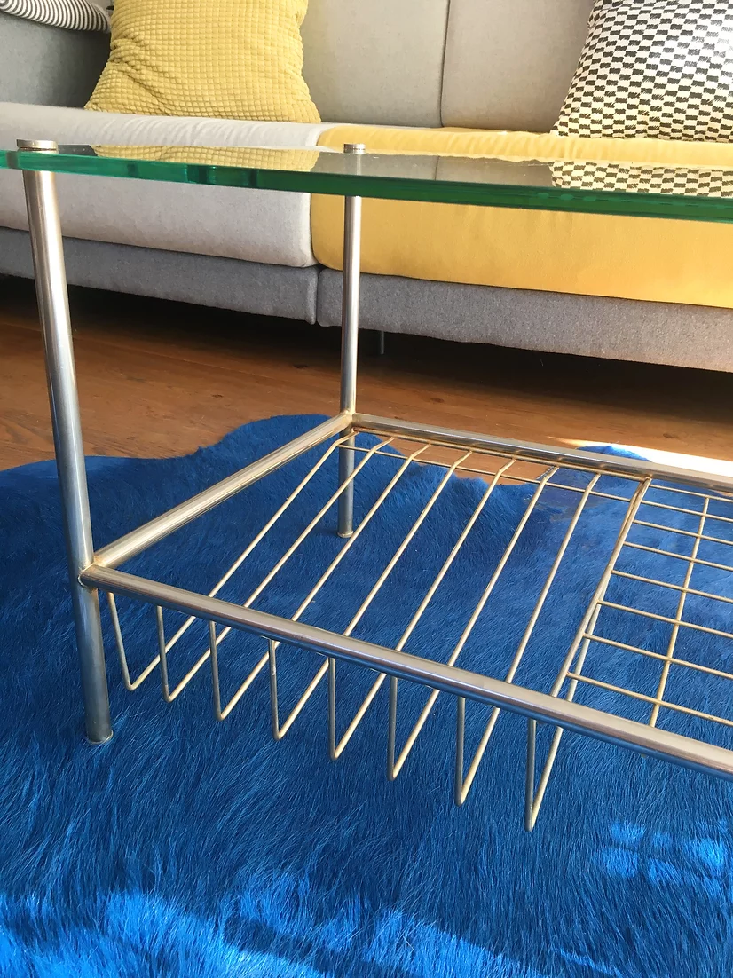 Glass coffee table with gold metal magazine holder