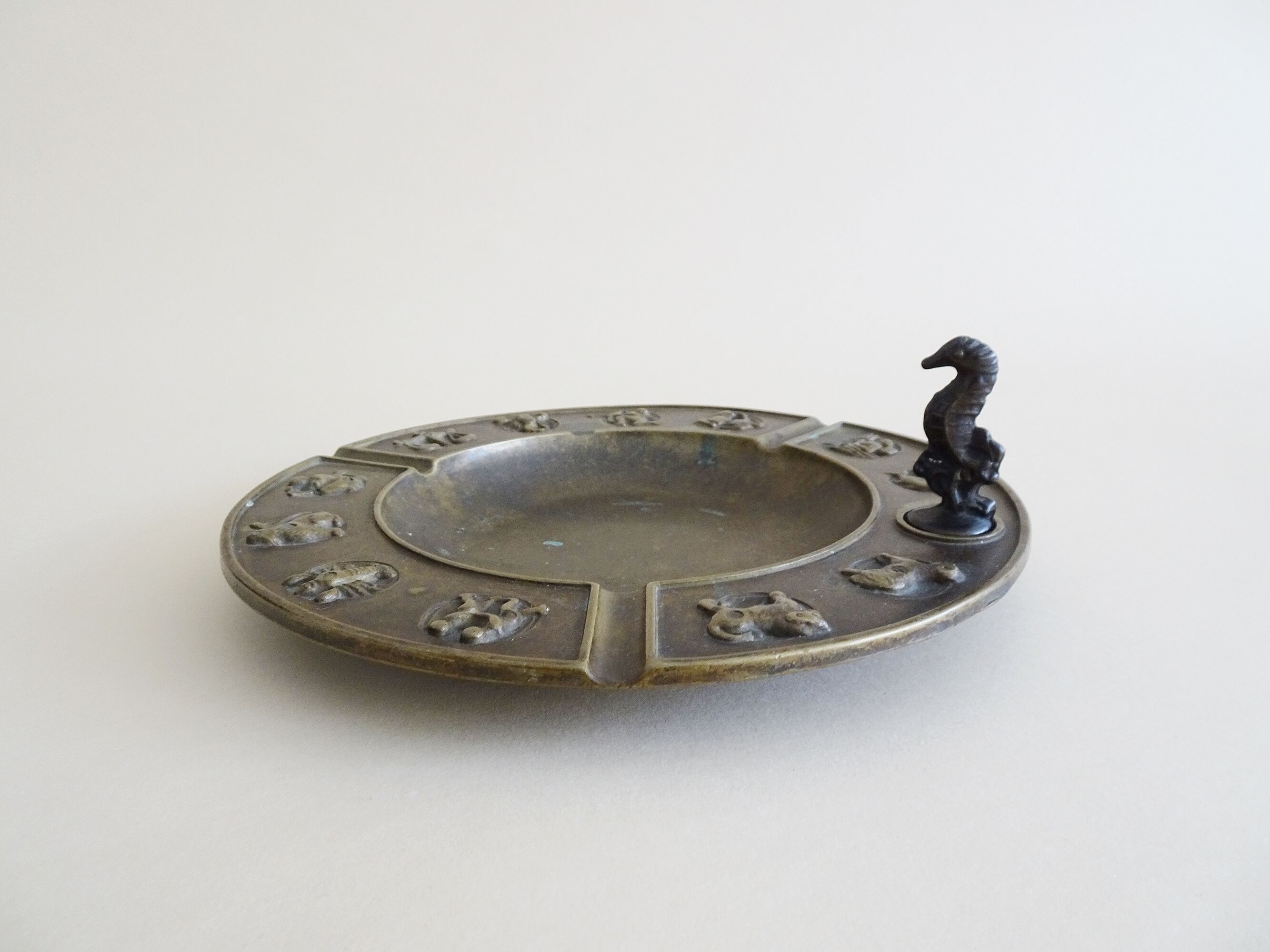 Luxa brass ashtray with zodiac relief and embers killer