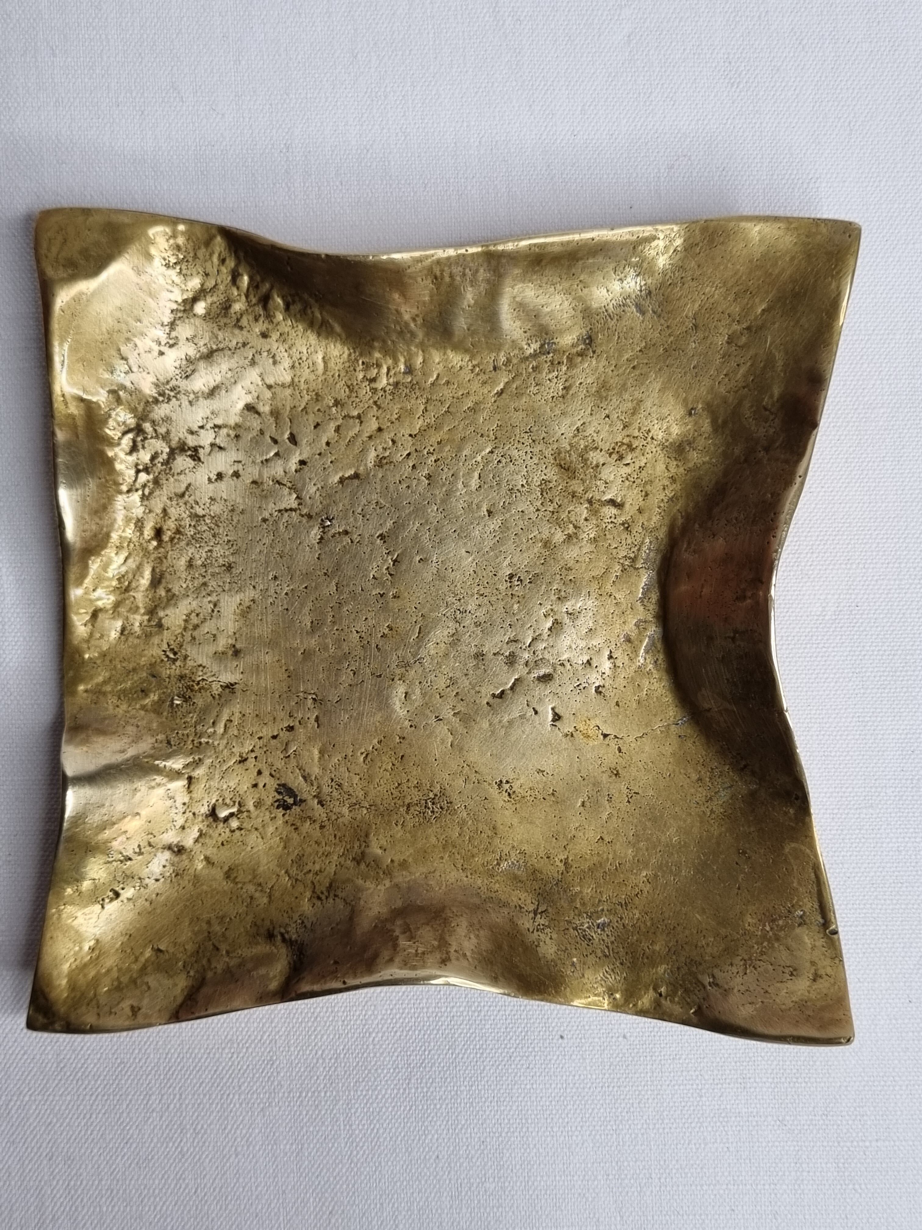 Empty pocket in polished brass representing a crumpled paper, signed CJ, 11.5 cm