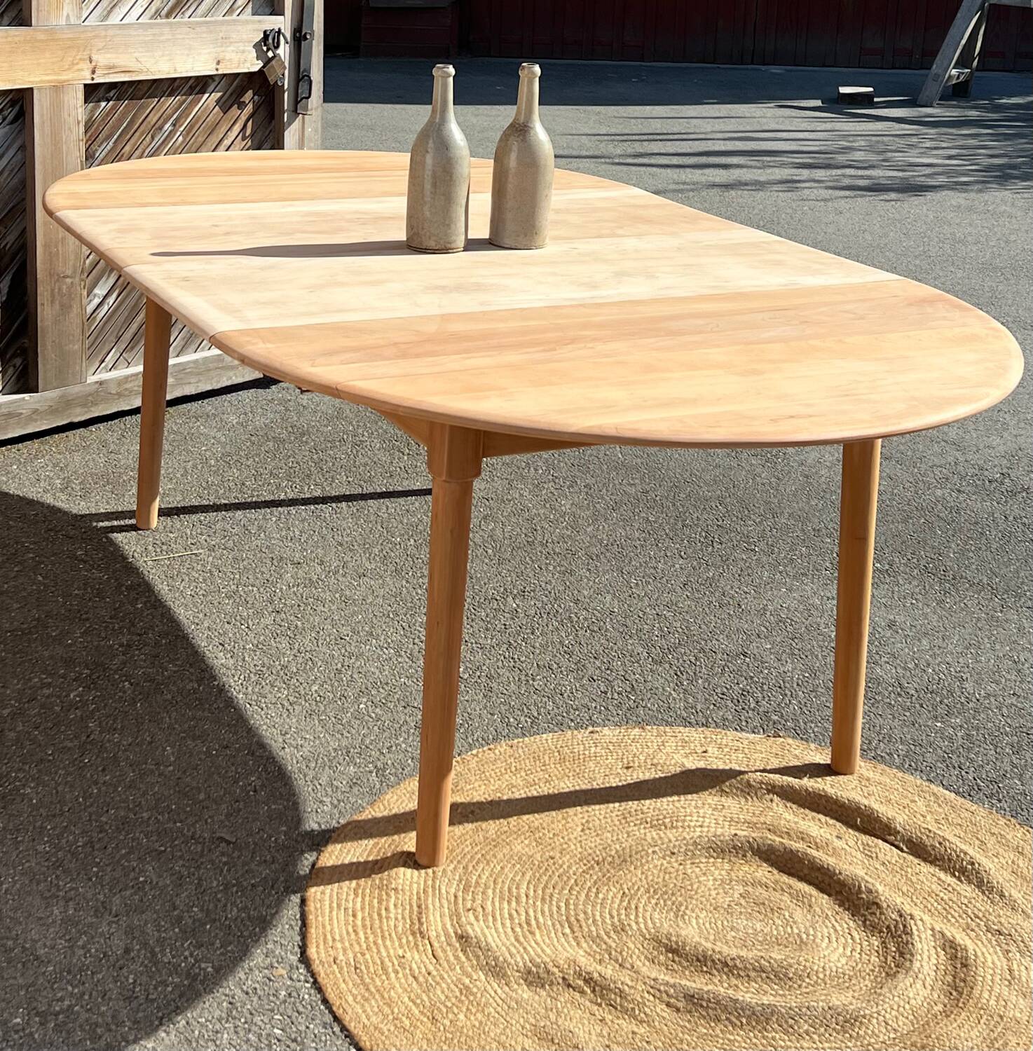 Large round family table with 2 extensions in solid raw wood.