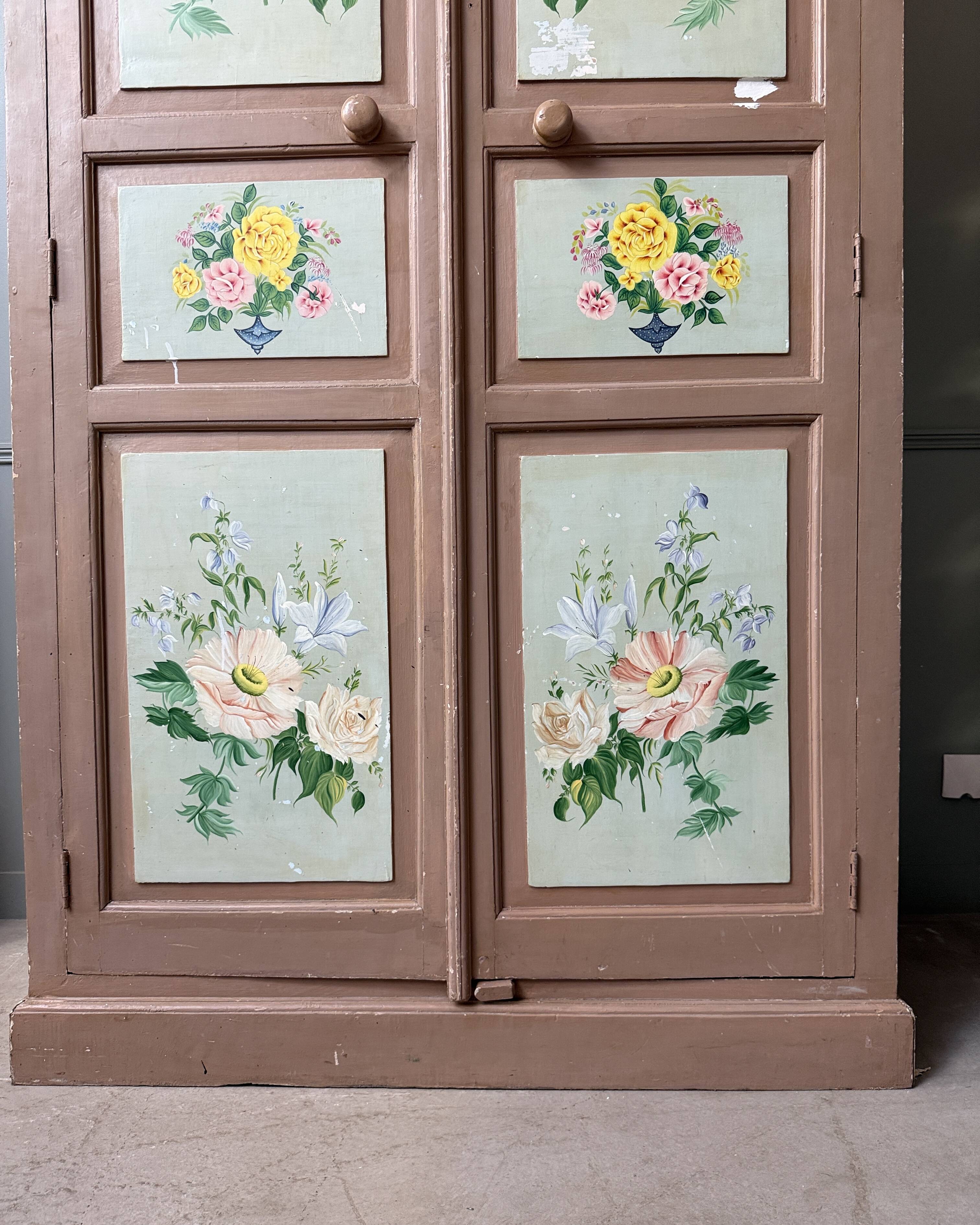 Large antique wardrobe painted with floral decoration.