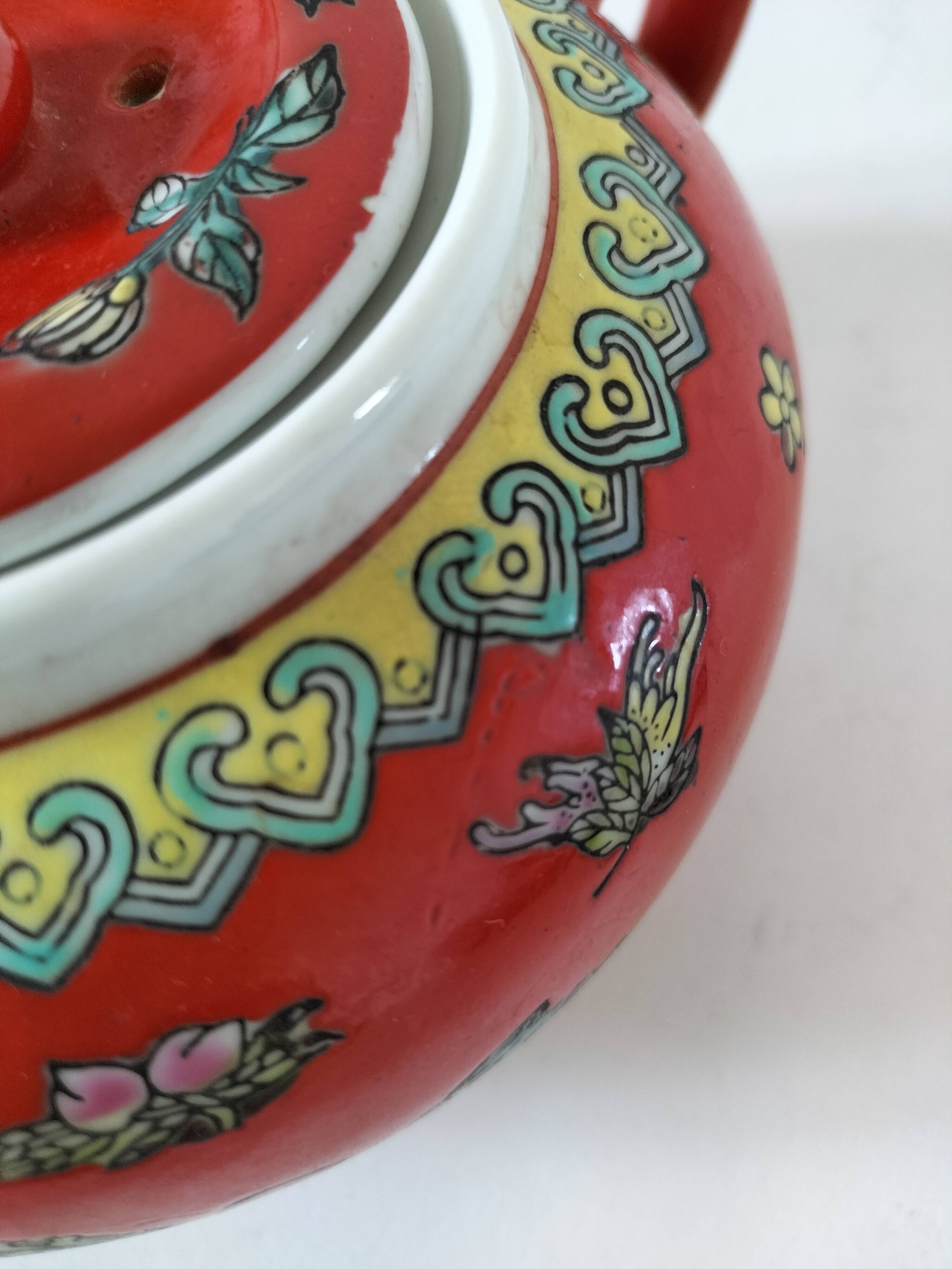 Vintage red Chinese teapot decorated with dragons and symbols.