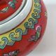 Vintage red Chinese teapot decorated with dragons and symbols.